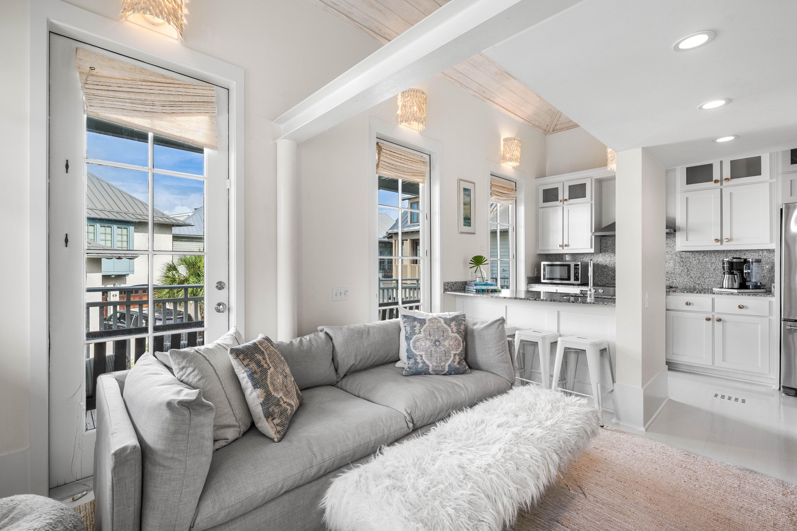 Sink into your plush gray sectional and admire the elegant white kitchen bathed in natural light from multiple windows.