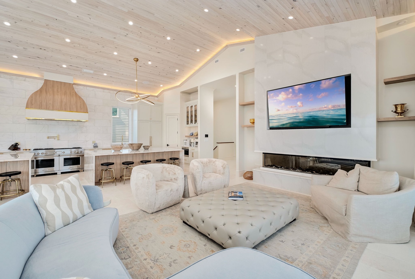 Unwind in this elegant open-concept living space where soft coastal colors meet modern comfort. Cozy seating, a calming fireplace, and ocean views on screen await your arrival.