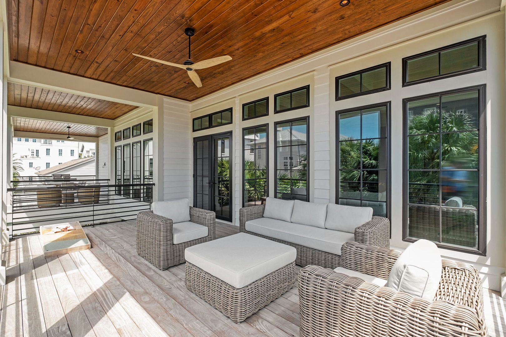 Relax on your private covered terrace with elegant wicker seating, warm wood ceilings, and peaceful views of the neighborhood.