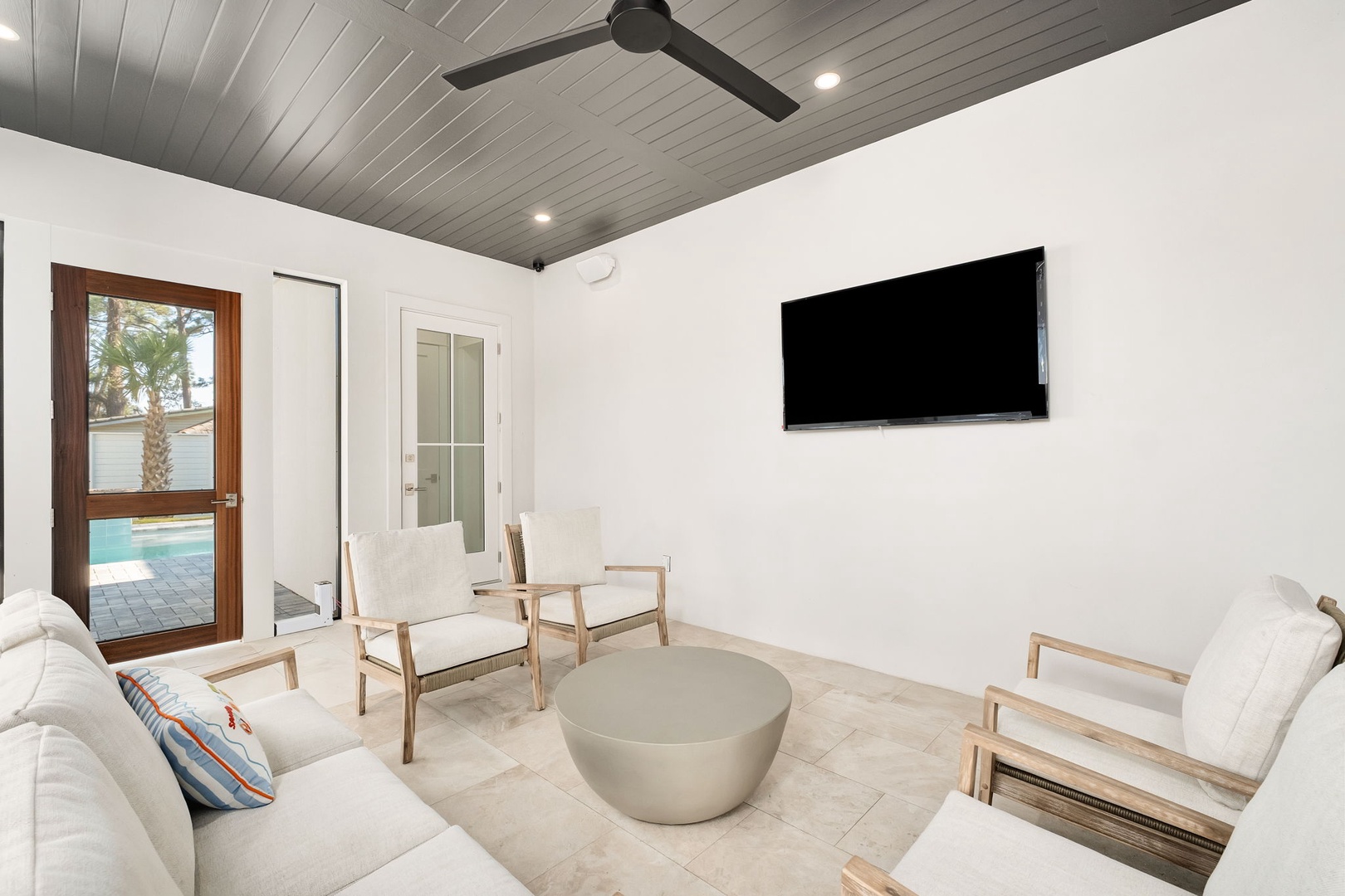 Unwind in your sleek living space with modern furnishings and a large TV, perfect for movie nights after pool days.