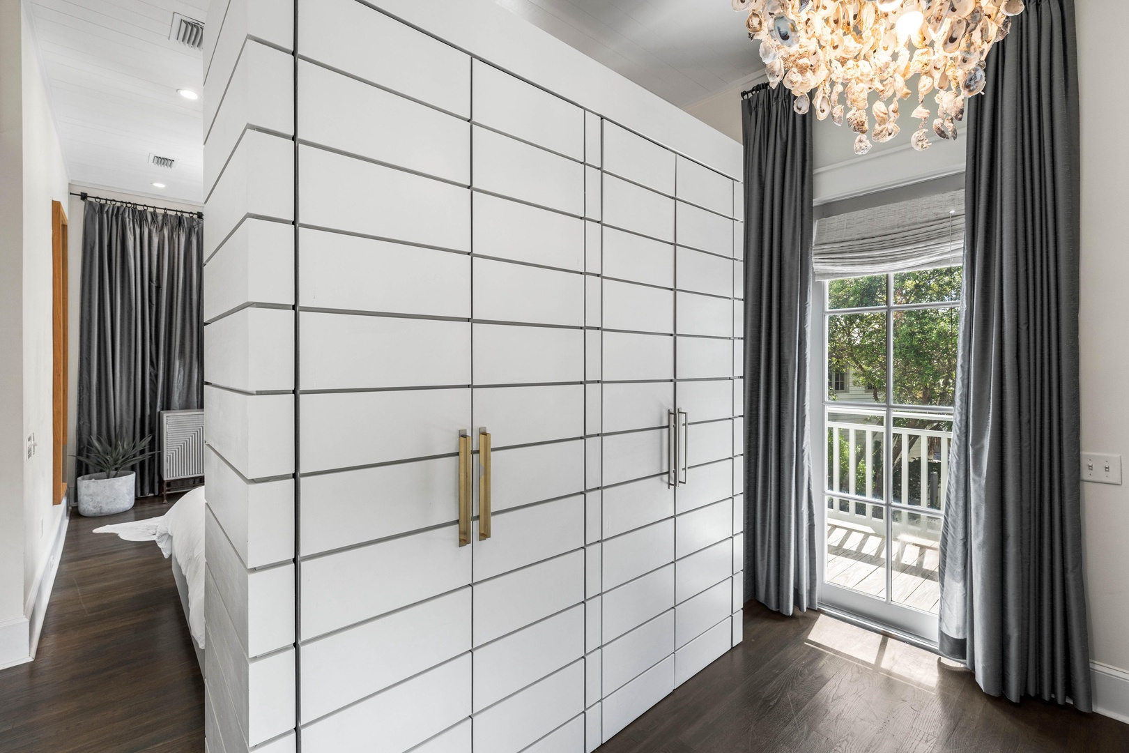 Your elegant bedroom features a stunning crystal chandelier and floor-to-ceiling wardrobe, with French doors opening to your private balcony.