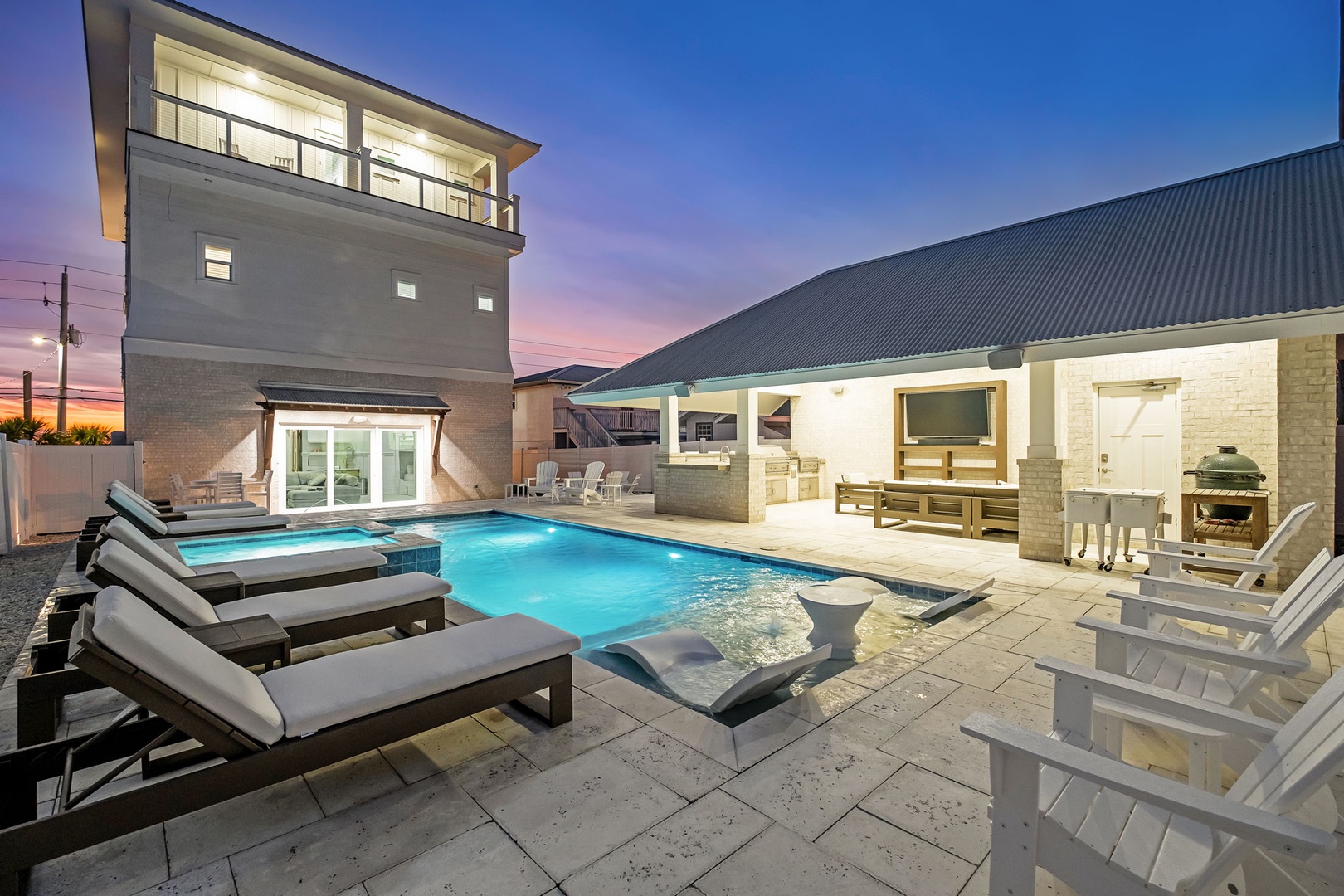 Modern vacation home with illuminated pool area and outdoor entertainment space at dusk.
