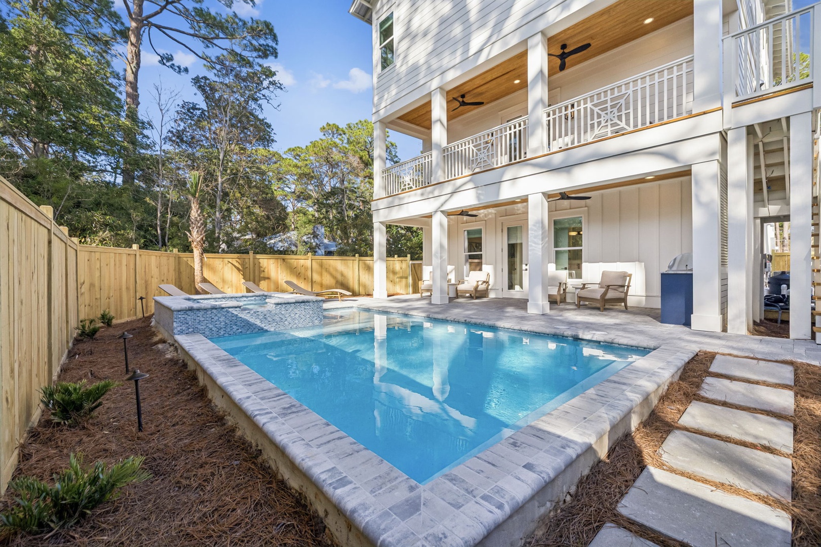 Dive into your private paradise! This pristine pool awaits your afternoon swims, surrounded by comfortable lounging areas and shaded porches.