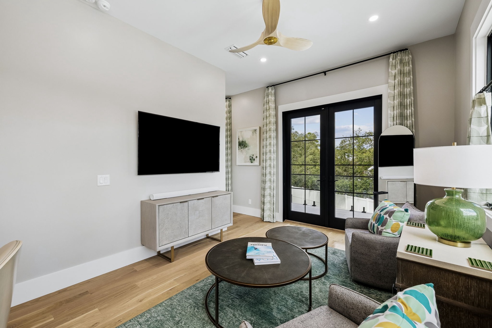 Unwind in your modern living room with stylish finishes and natural light streaming through French doors. A cozy spot where comfort meets contemporary design.