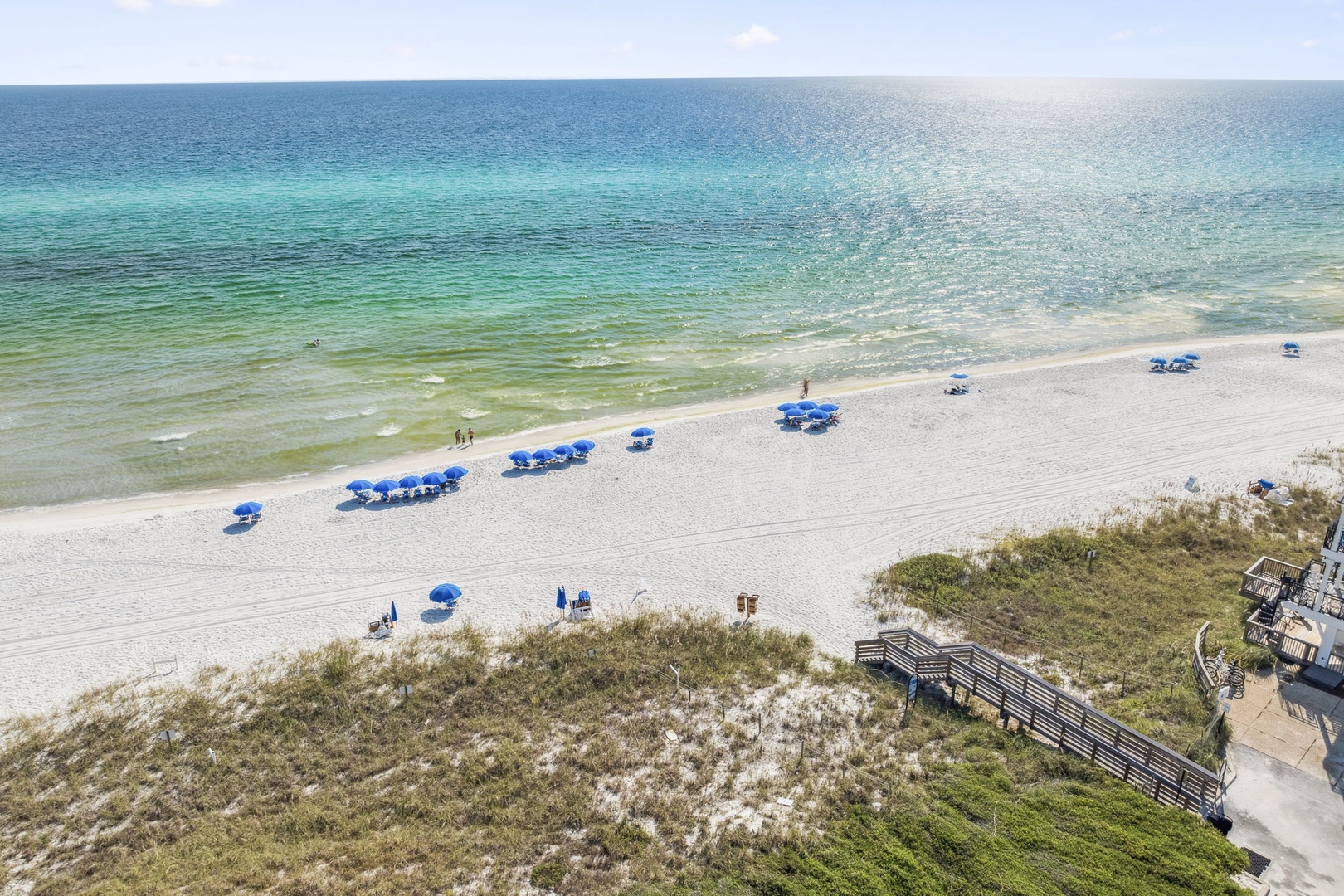 Pristine beachfront with crystal-clear waters, soft sand, and convenient beach access walkway nearby.