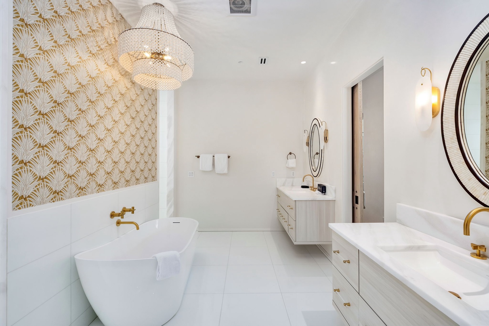Step into your luxurious spa-like bathroom, where golden accents and elegant fixtures create a serene retreat. The statement chandelier and soaking tub invite you to unwind in style.