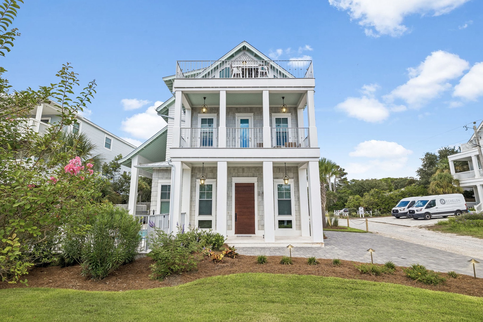 This stunning coastal home greets you with elegant architecture, spacious balconies, and lush landscaping—a perfect retreat for a relaxing getaway near the beach.