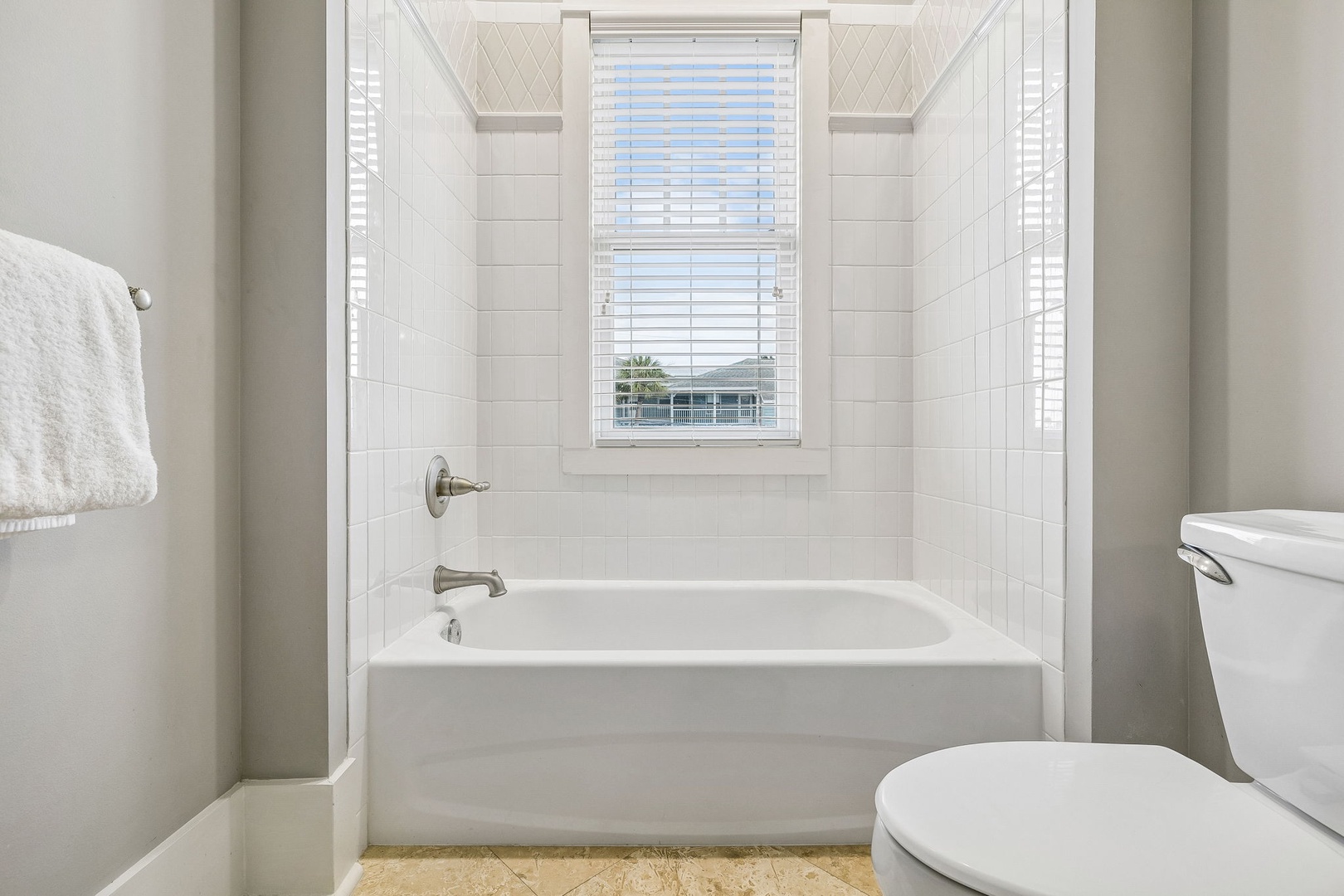 Unwind in your bright, immaculate bathroom with its classic subway tile surround and soaking tub—your personal oasis after a day of exploring.