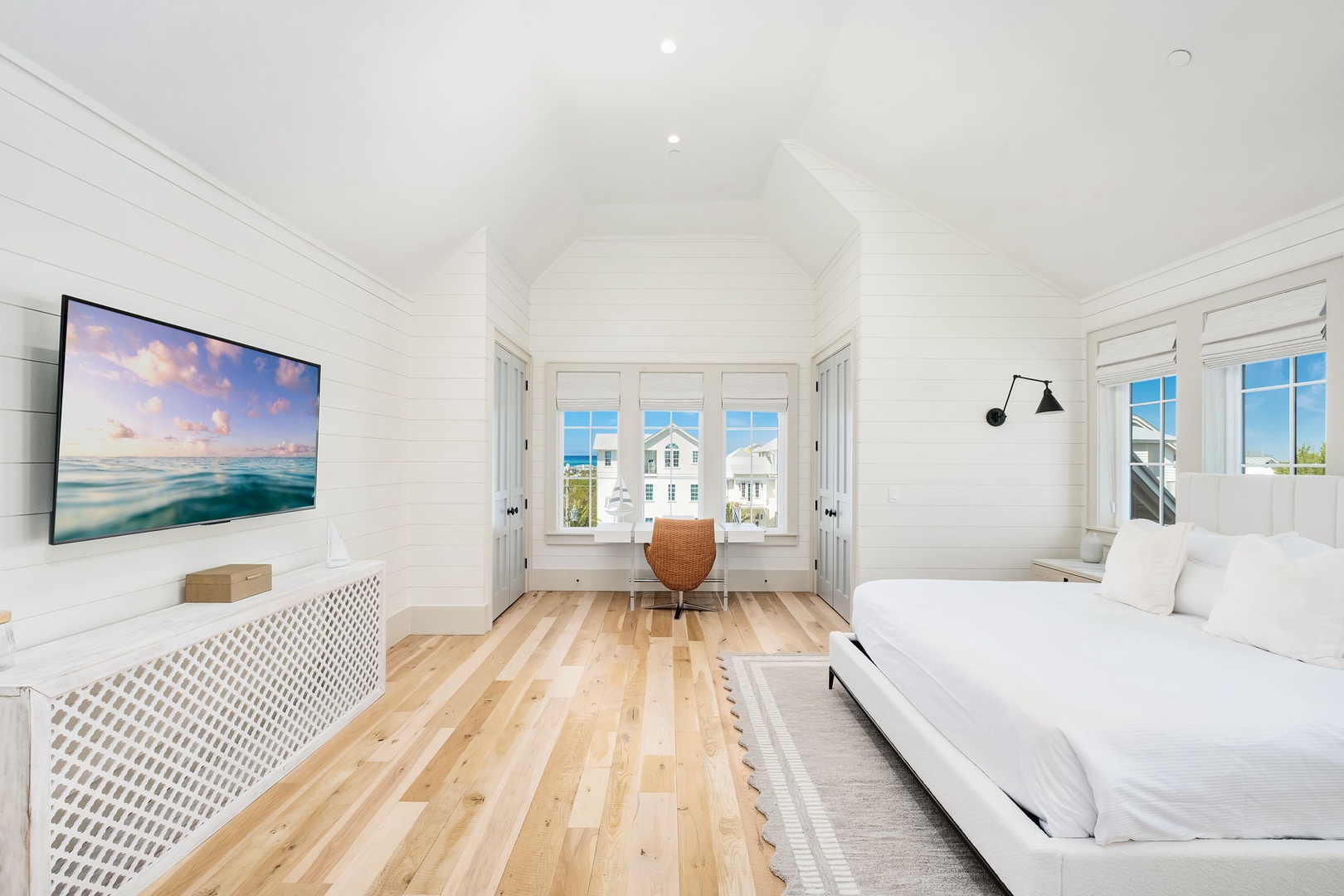 Wake up in your serene coastal bedroom with ocean views through charming windows and modern comforts.