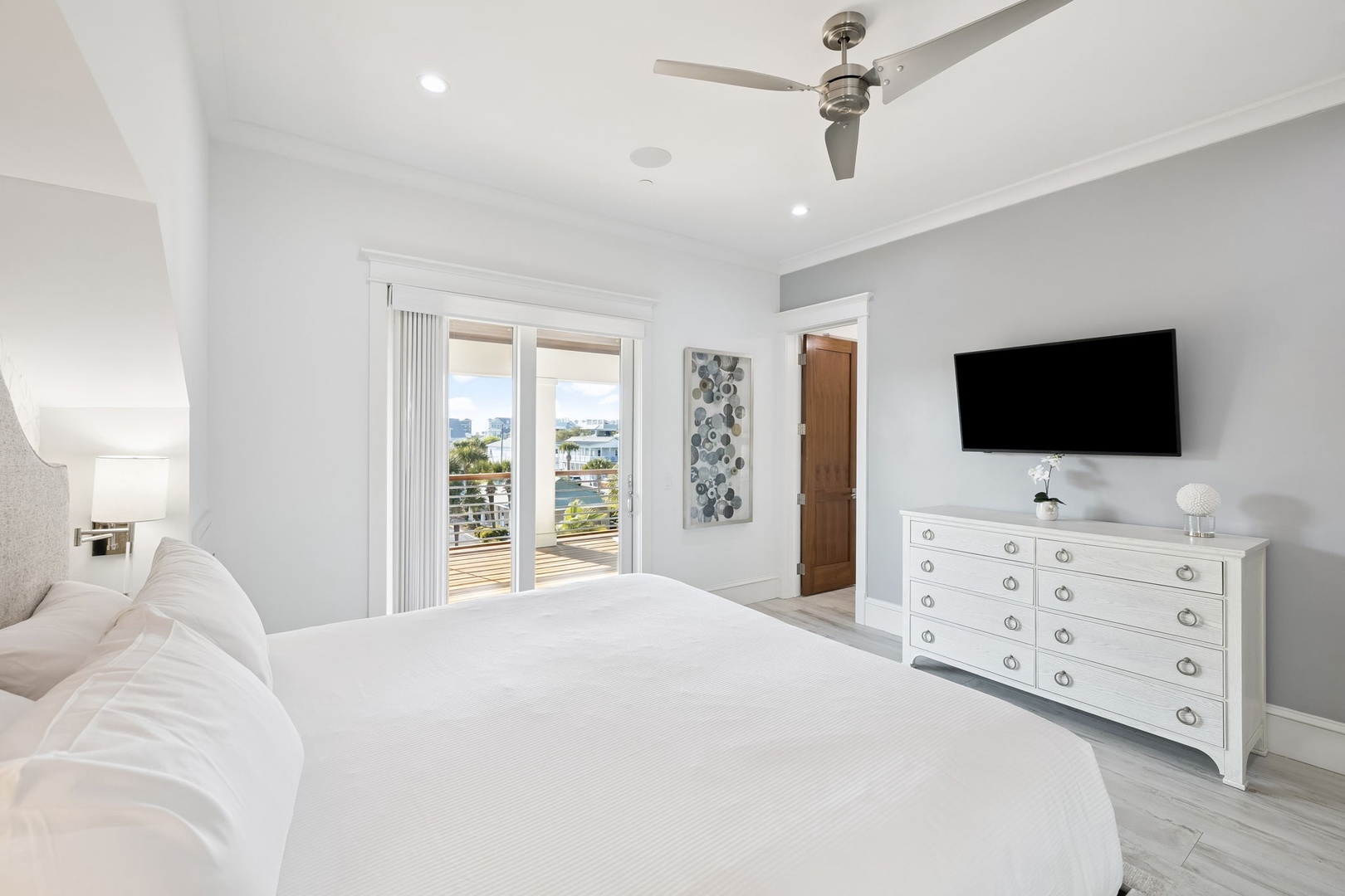Drift off peacefully in your serene bedroom, complete with plush bedding, modern TV, and balcony access offering lovely views.