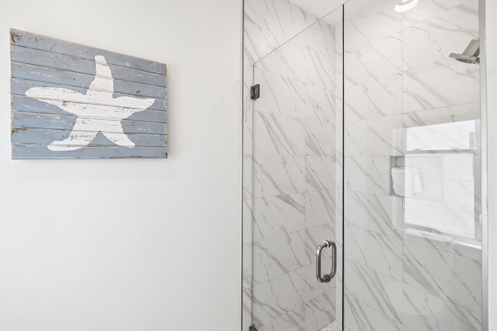 Step into your spa-like bathroom featuring stunning marble shower walls and coastal-inspired decor that brings beach vibes to your daily routine.