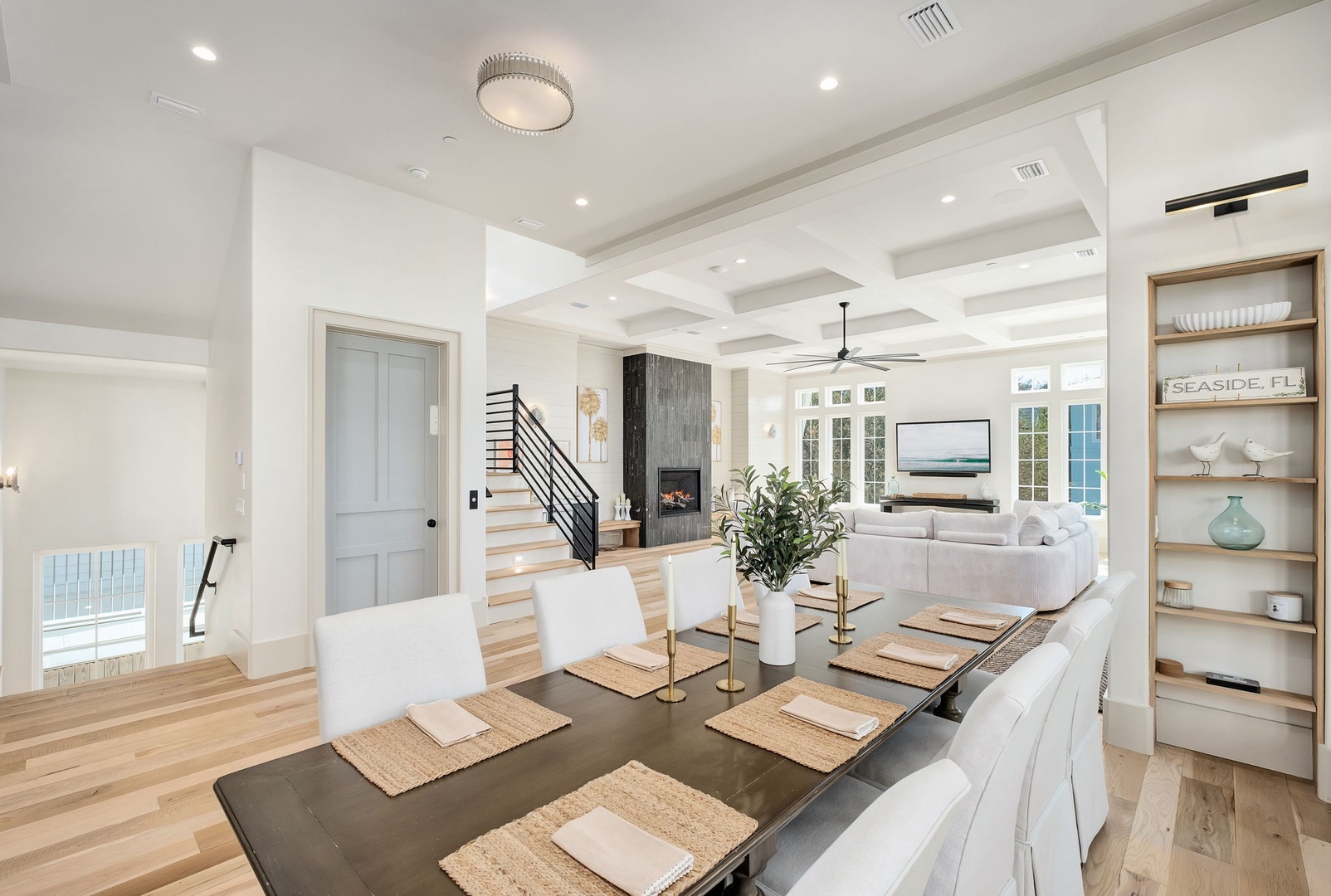 Your elegant open-concept living unfolds with soaring coffered ceilings, where natural light flows between your dining space and cozy fireplace lounge.