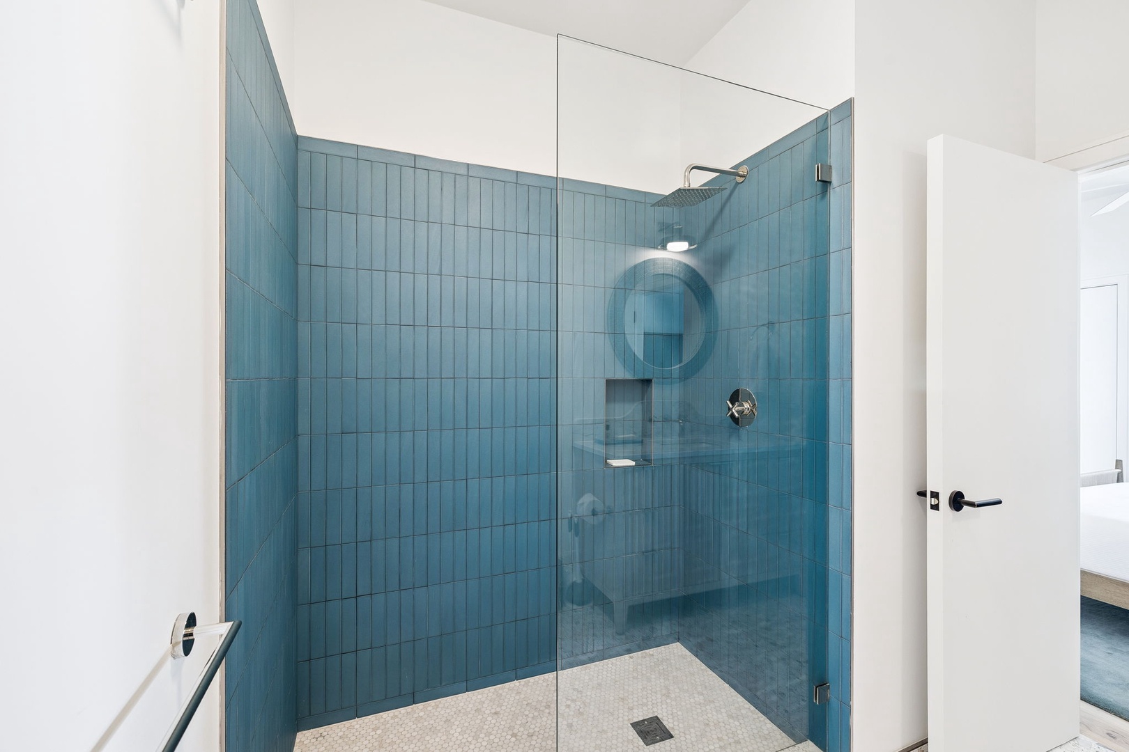 Step into your private spa-like shower featuring stunning blue subway tiles and rainfall showerhead for the ultimate relaxation.