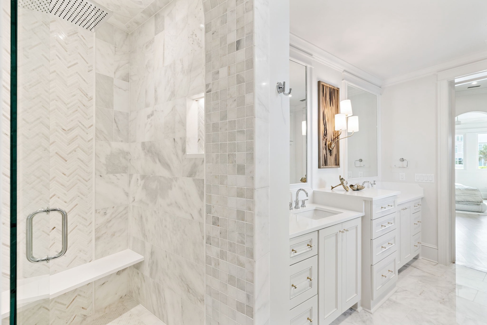 Elegant marble tiling and clean white cabinetry create a luxurious, serene retreat for your morning and evening routines.
