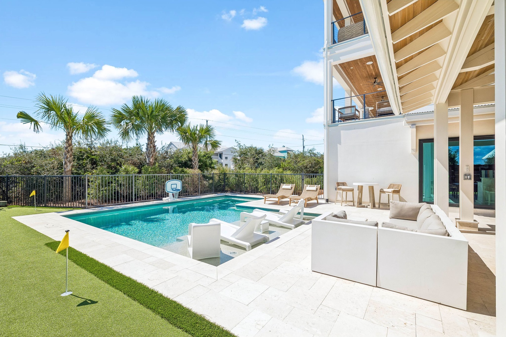 Modern coastal retreat featuring your private pool, covered outdoor lounge, and basketball court—perfect for sunny days and warm evenings under the palms.