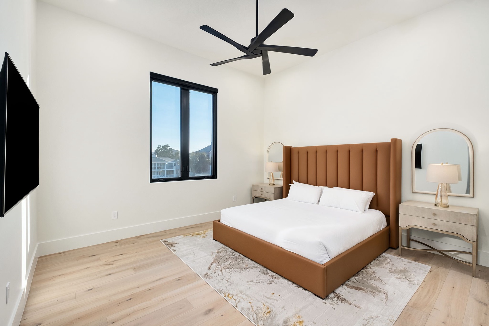 Unwind in your serene bedroom with plush bedding, modern furnishings, and a gentle ceiling fan creating the perfect sleep sanctuary.