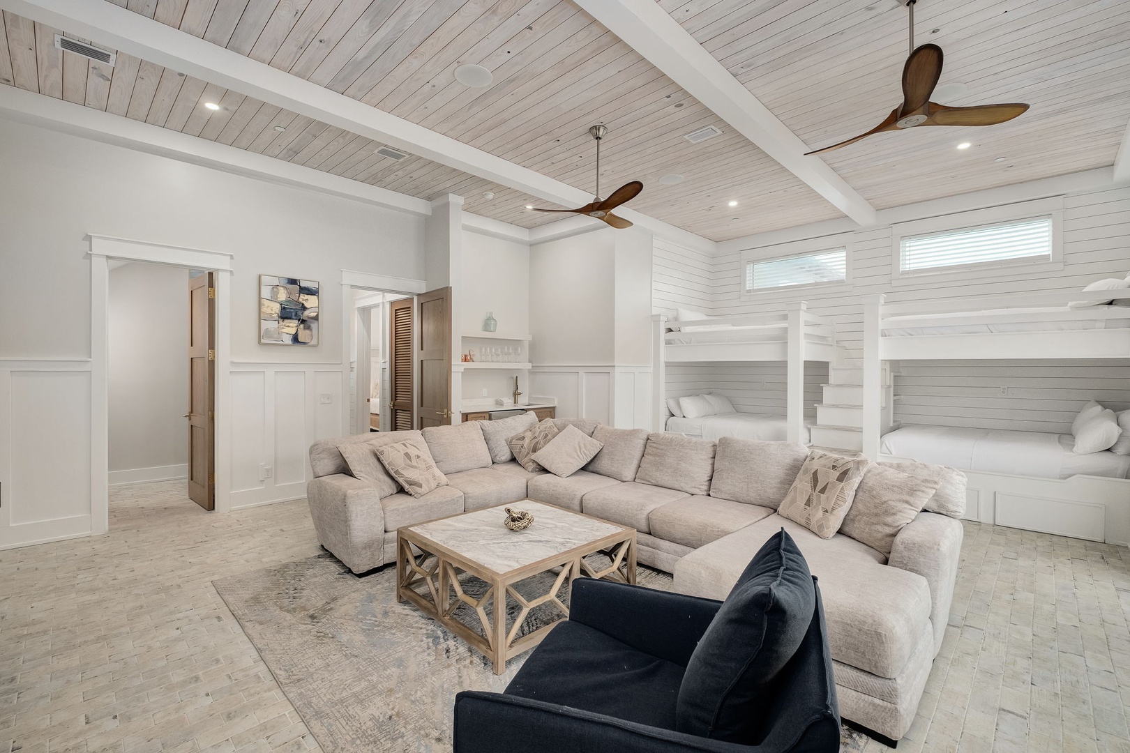 Unwind in your spacious living room featuring a plush sectional sofa and custom bunk beds, perfect for family gatherings under soaring ceilings.