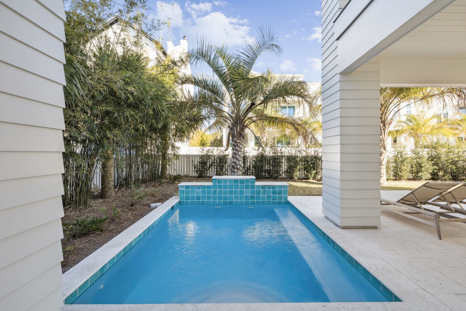 Your private oasis awaits with crystal-clear waters surrounded by swaying palms and modern design elements for the perfect poolside retreat.