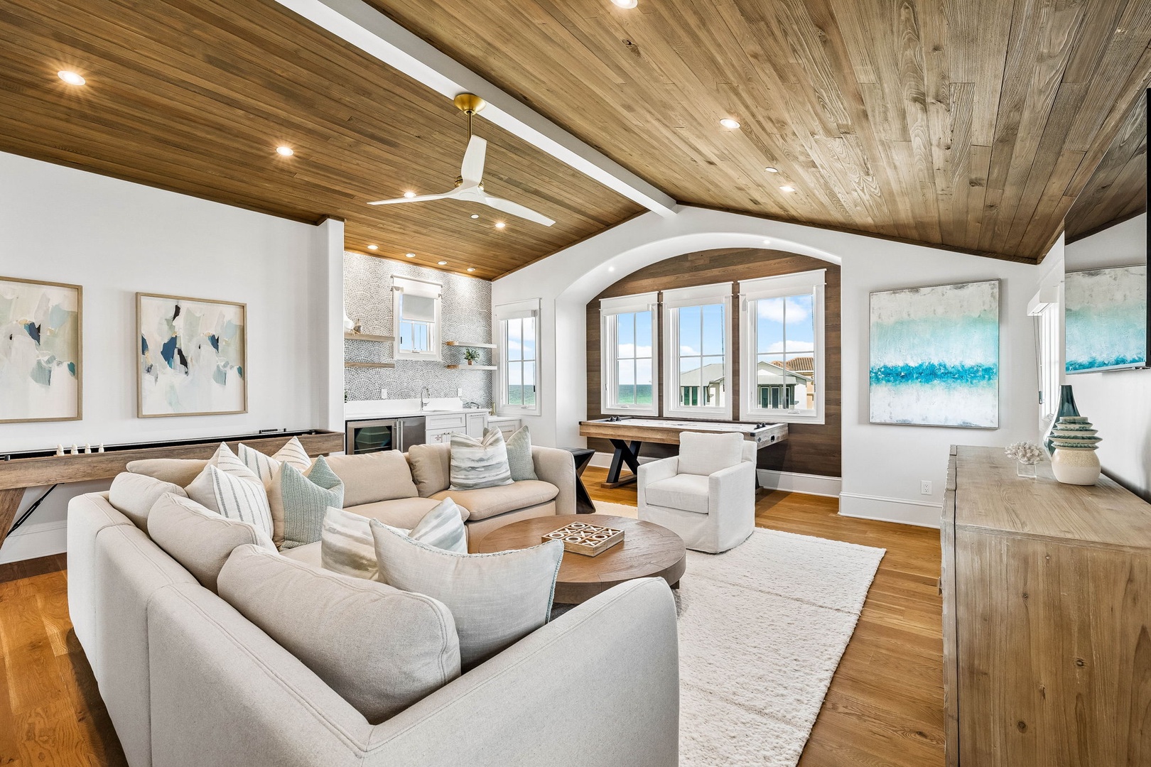Unwind in your spacious living room where stunning wood ceilings, plush seating, and coastal artwork create a warm retreat. Ocean views frame every moment here.