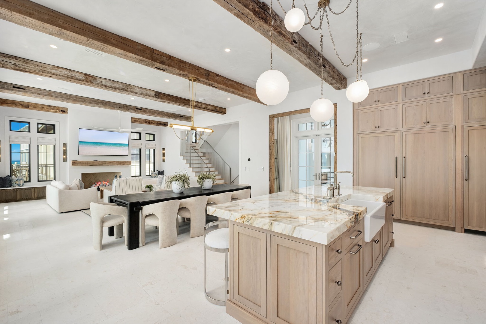 Your open-concept kitchen flows into elegant dining and living spaces, featuring marble countertops and warm wood finishes throughout.