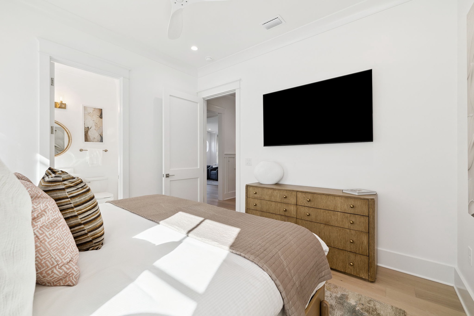 Sink into your comfortable bed while watching your favorite shows on the large wall-mounted TV in this bright, modern bedroom.