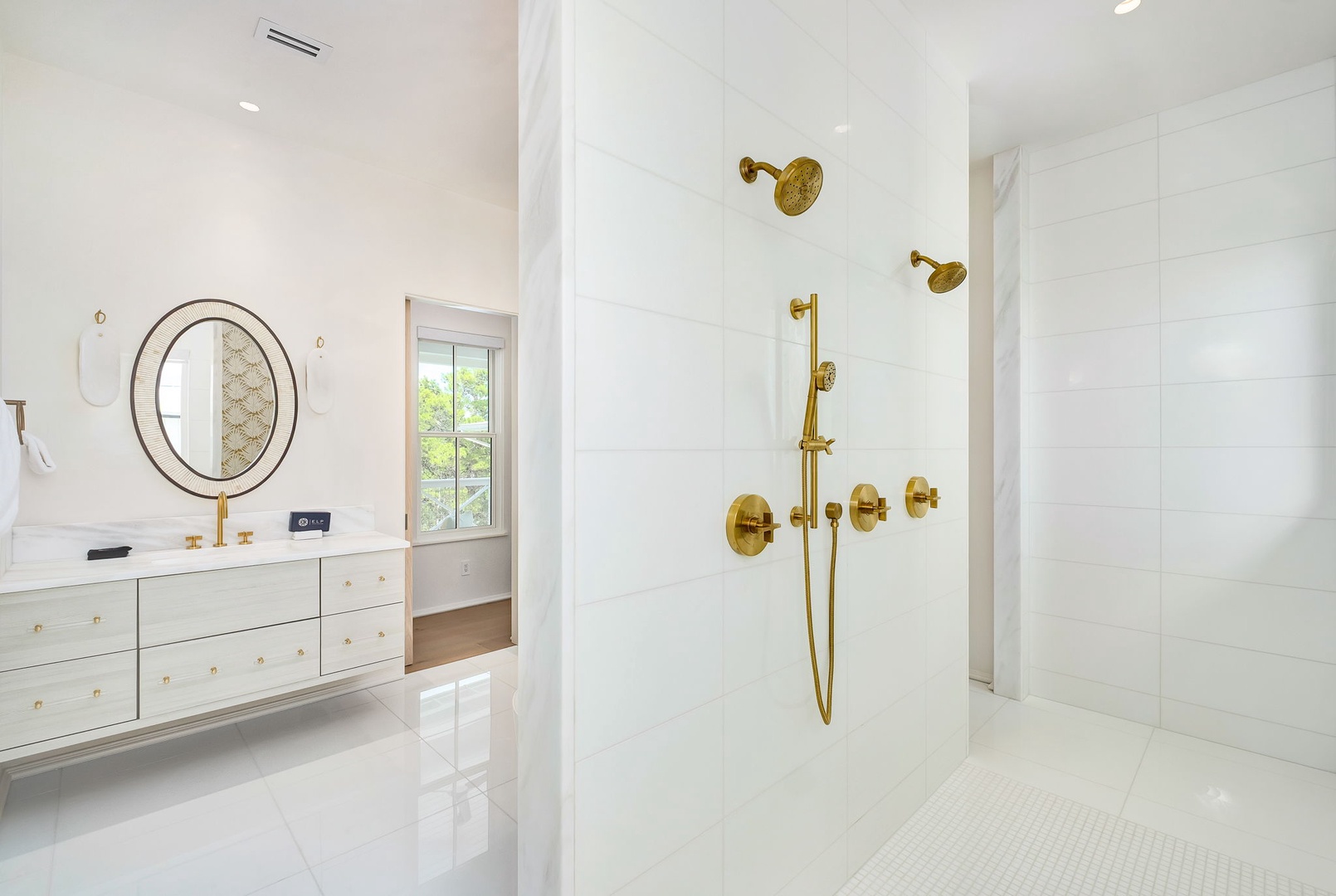 Step into a spa-like sanctuary with gleaming white tile, elegant gold fixtures, and a luxurious walk-in shower designed for your ultimate relaxation.