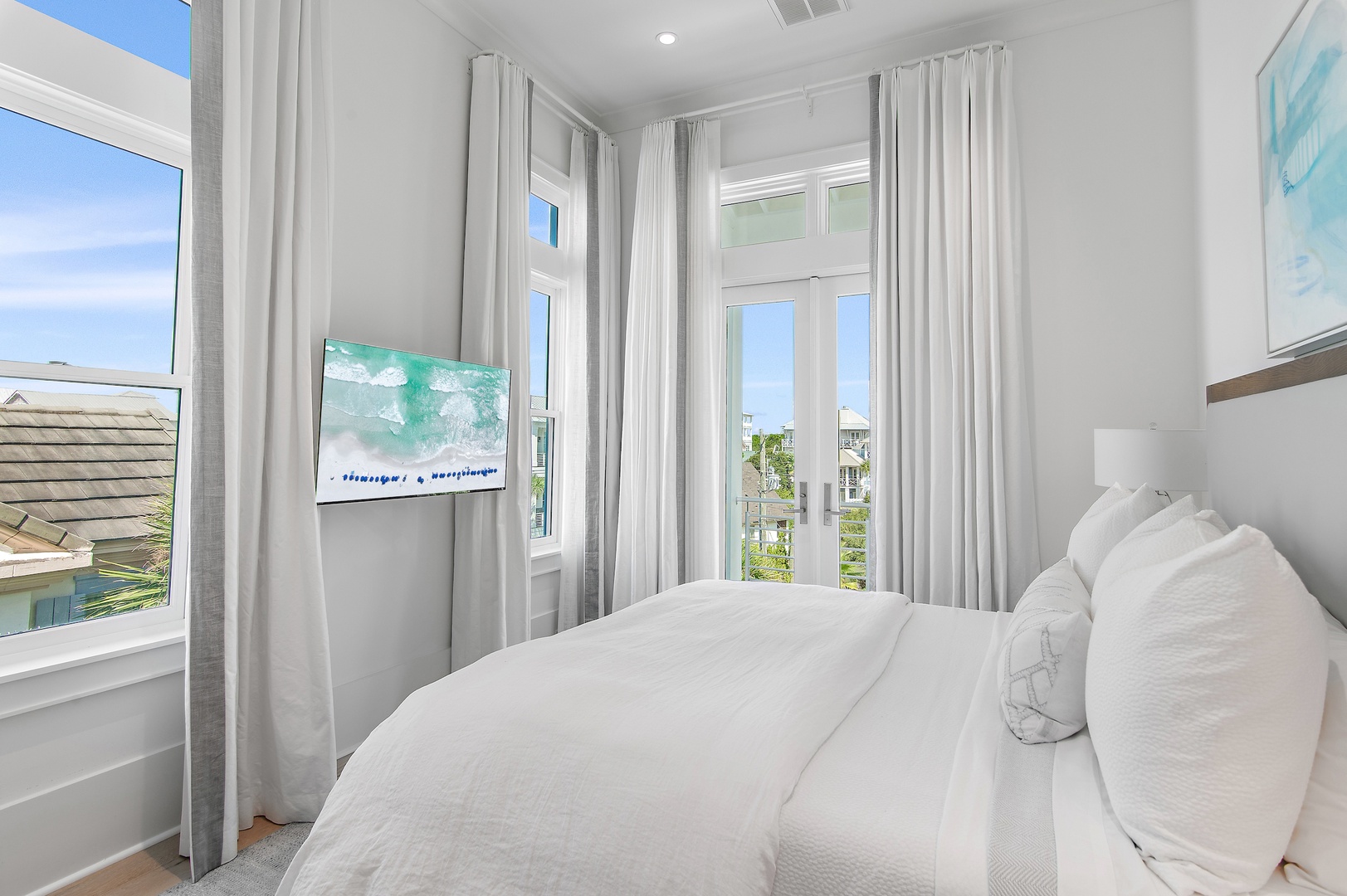 Sink into the plush white bedding and let natural light pour through the windows. Your peaceful coastal-inspired retreat awaits with soft linens and calming tones.