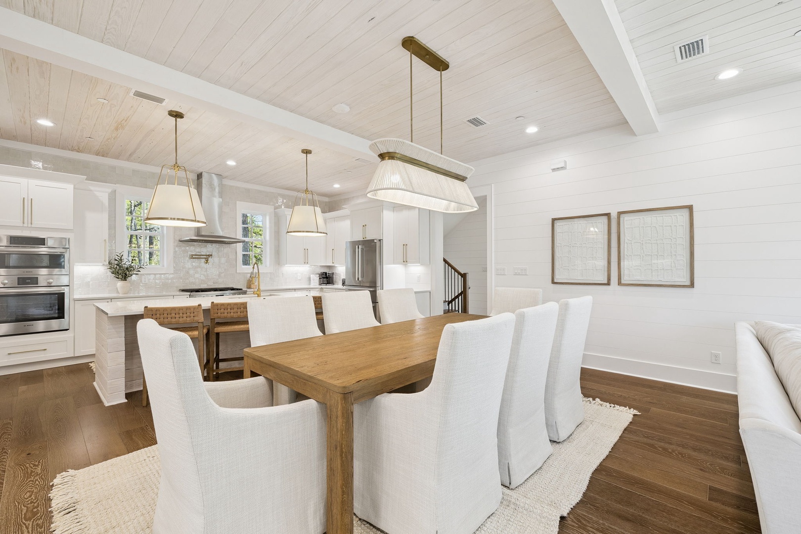 Gather around your spacious dining table beneath elegant pendant lighting, where memorable meals unfold in this bright, open-concept space.