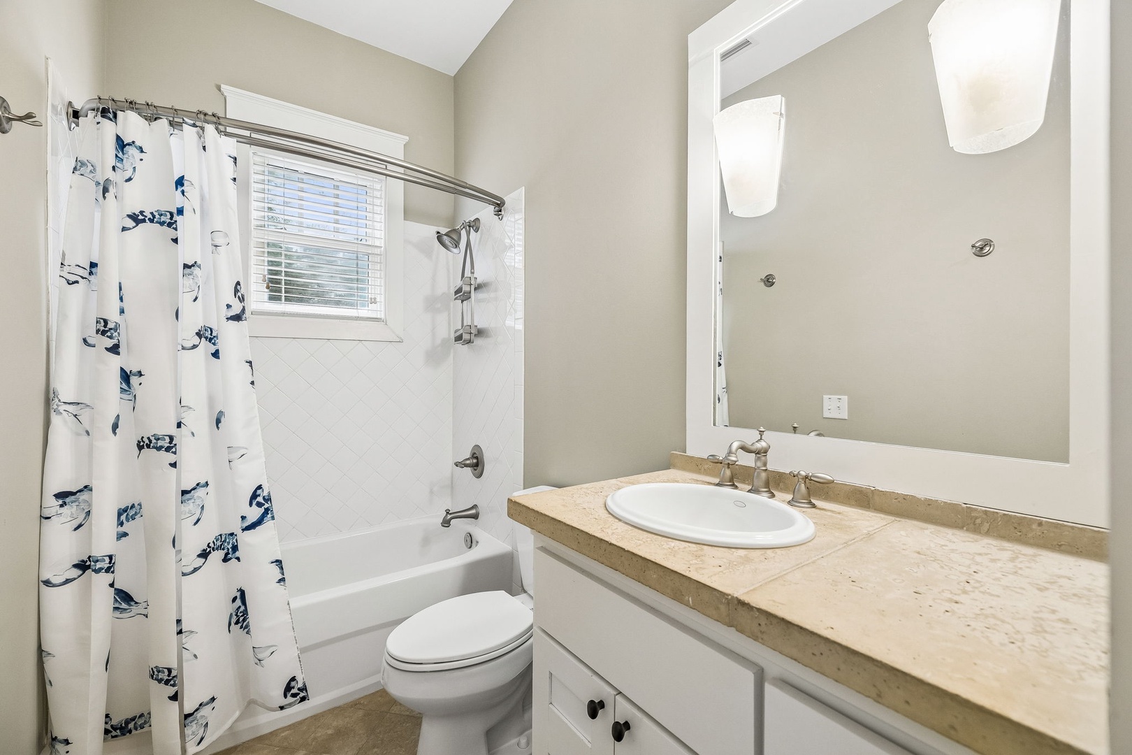 Step into your private, thoughtfully designed bathroom featuring a full tub-shower combo, crisp white vanity, and plenty of natural light streaming through the window for a fresh, airy feel.
