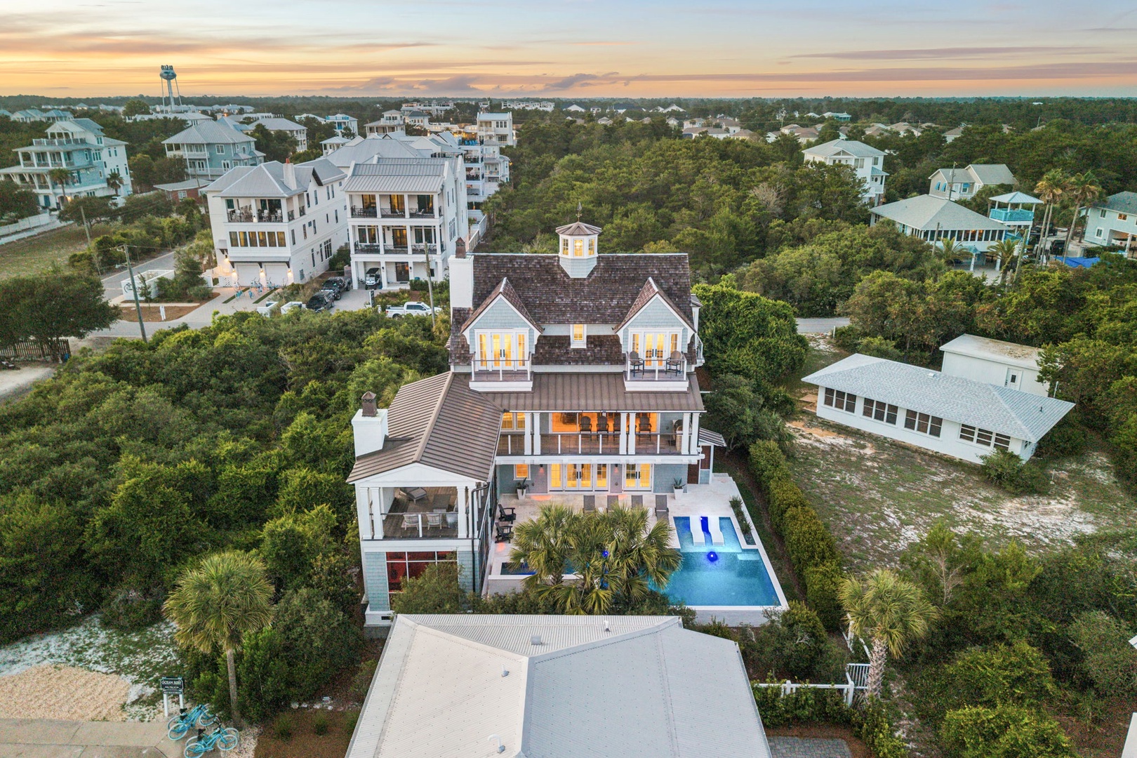 A stunning coastal property nestled among lush greenery in a serene beach neighborhood, featuring elegant architecture, a private pool, and proximity to the shoreline.