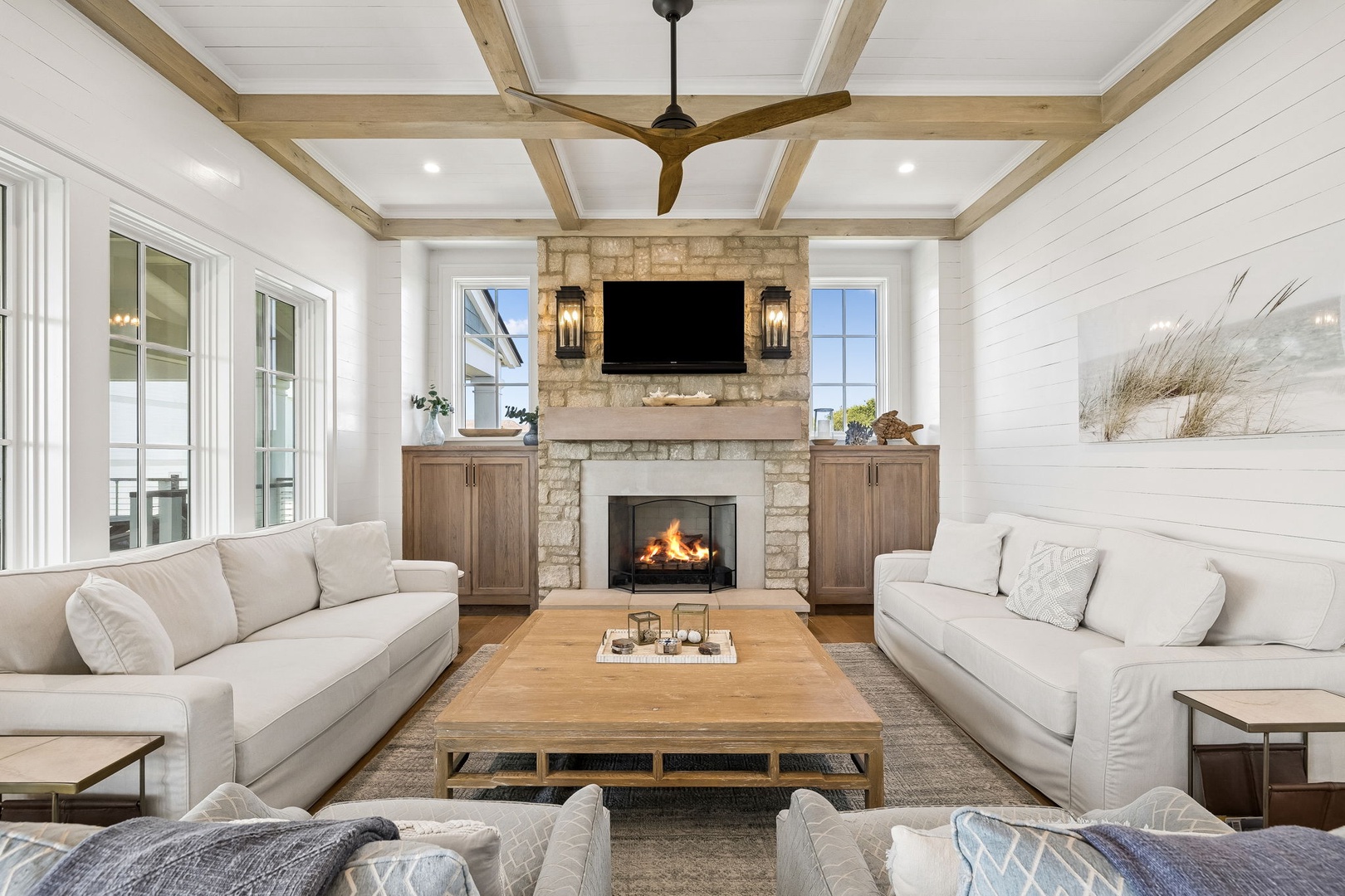 Unwind in your bright living space with plush seating around a cozy fireplace, vaulted ceiling, and coastal charm welcoming you home.