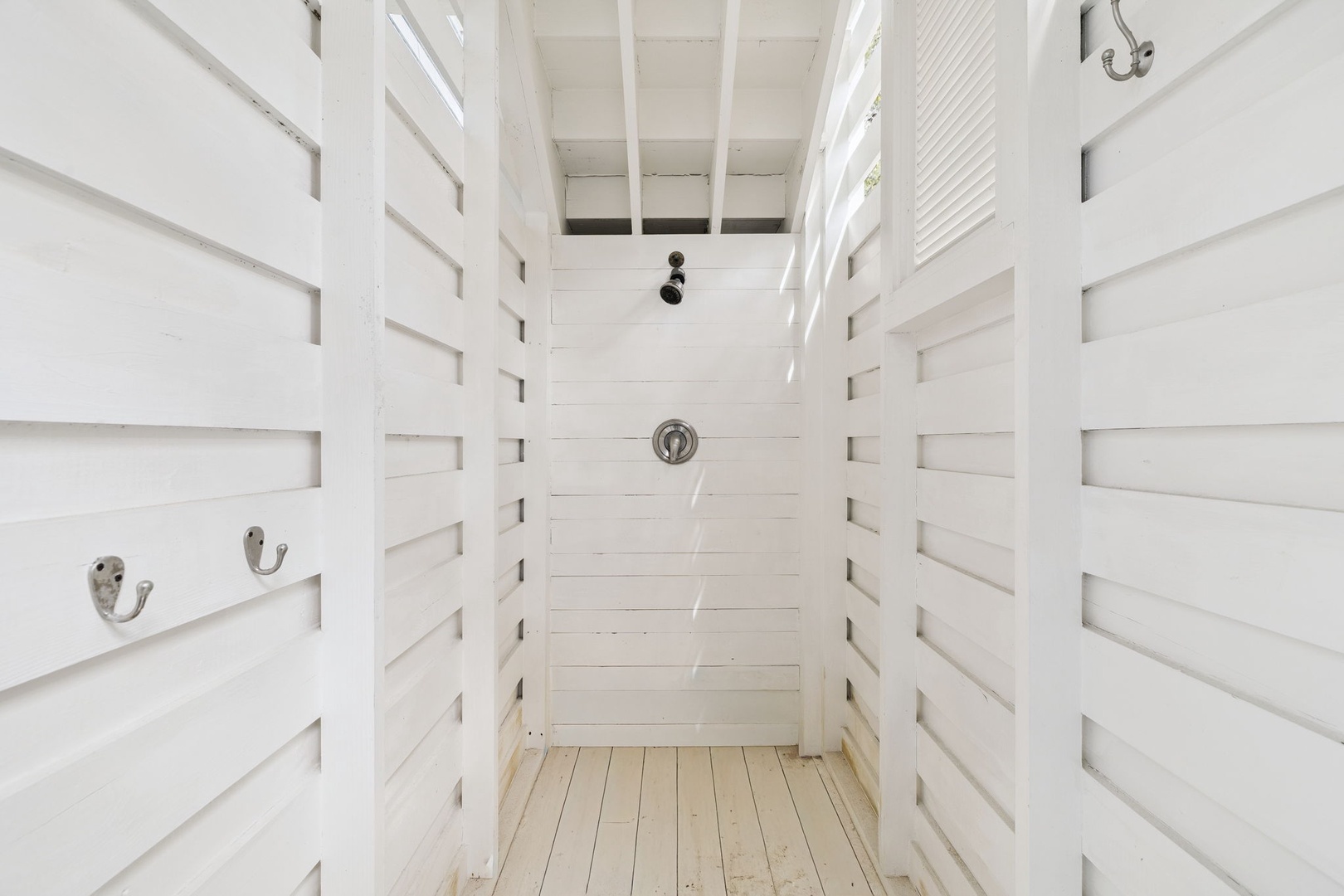 Rinse off the beach salt in your private outdoor shower, surrounded by crisp white walls and open-air ceiling for a refreshing tropical experience.