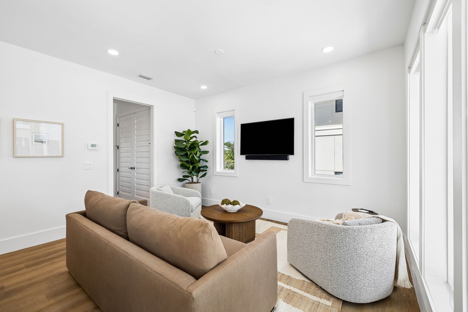 Settle into your bright, airy living room where modern comfort meets relaxed coastal style—perfect for unwinding after a day at the beach.