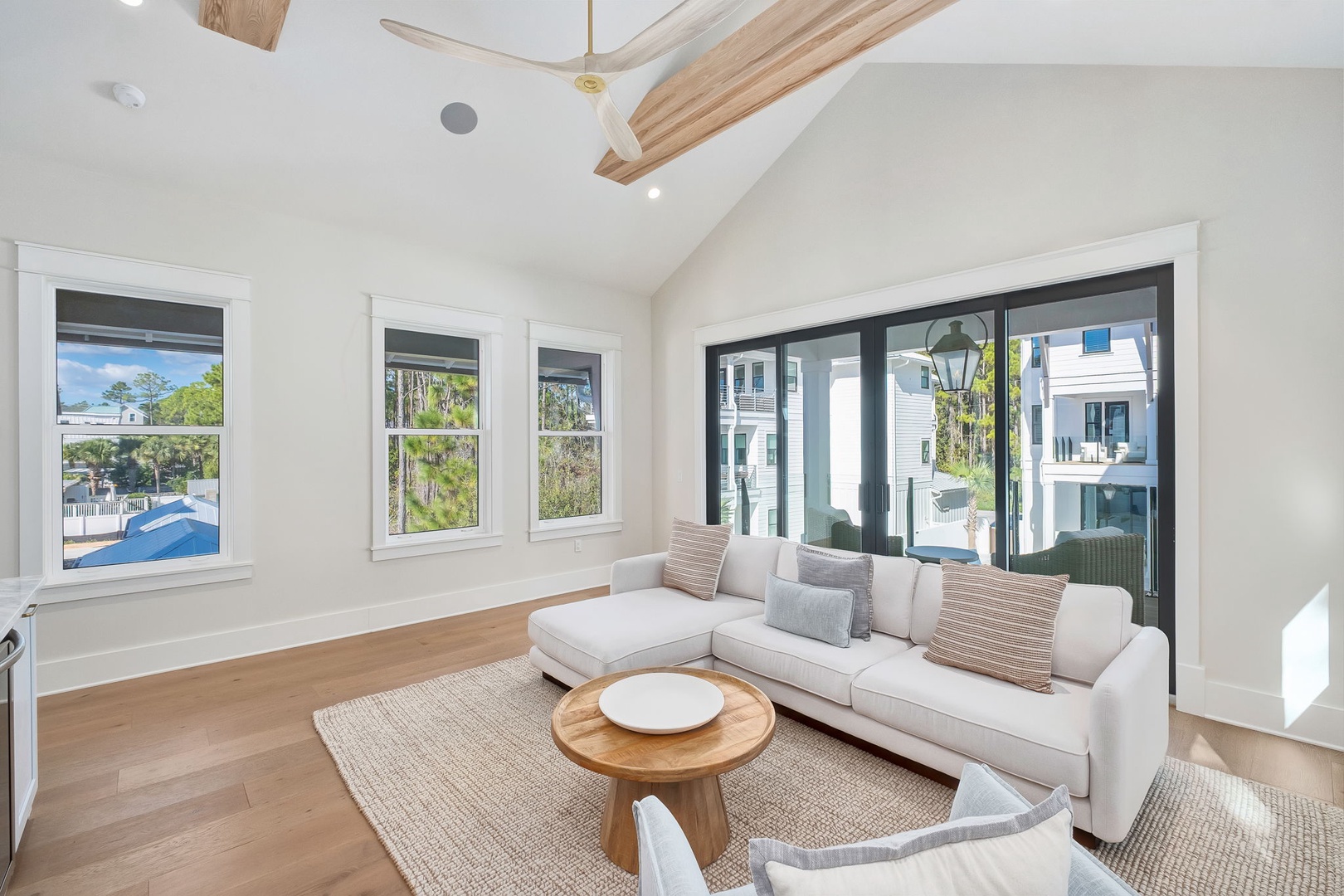 Your bright and breezy living space welcomes you with soaring ceilings, coastal breezes from the ceiling fan, and comfortable seating perfect for unwinding after a day of adventure.