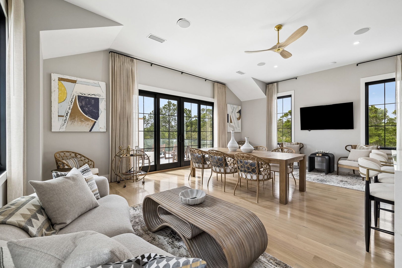 Step into your open-concept living space where natural light floods through floor-to-ceiling windows, revealing stunning garden views. Gather around the dining table or sink into the plush seating—your perfect retreat awaits.