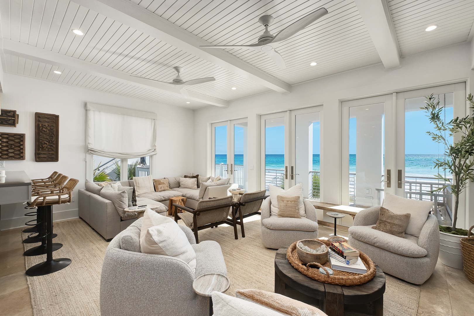 Sink into plush seating while ocean waves dance beyond your floor-to-ceiling windows in this bright, airy living space.