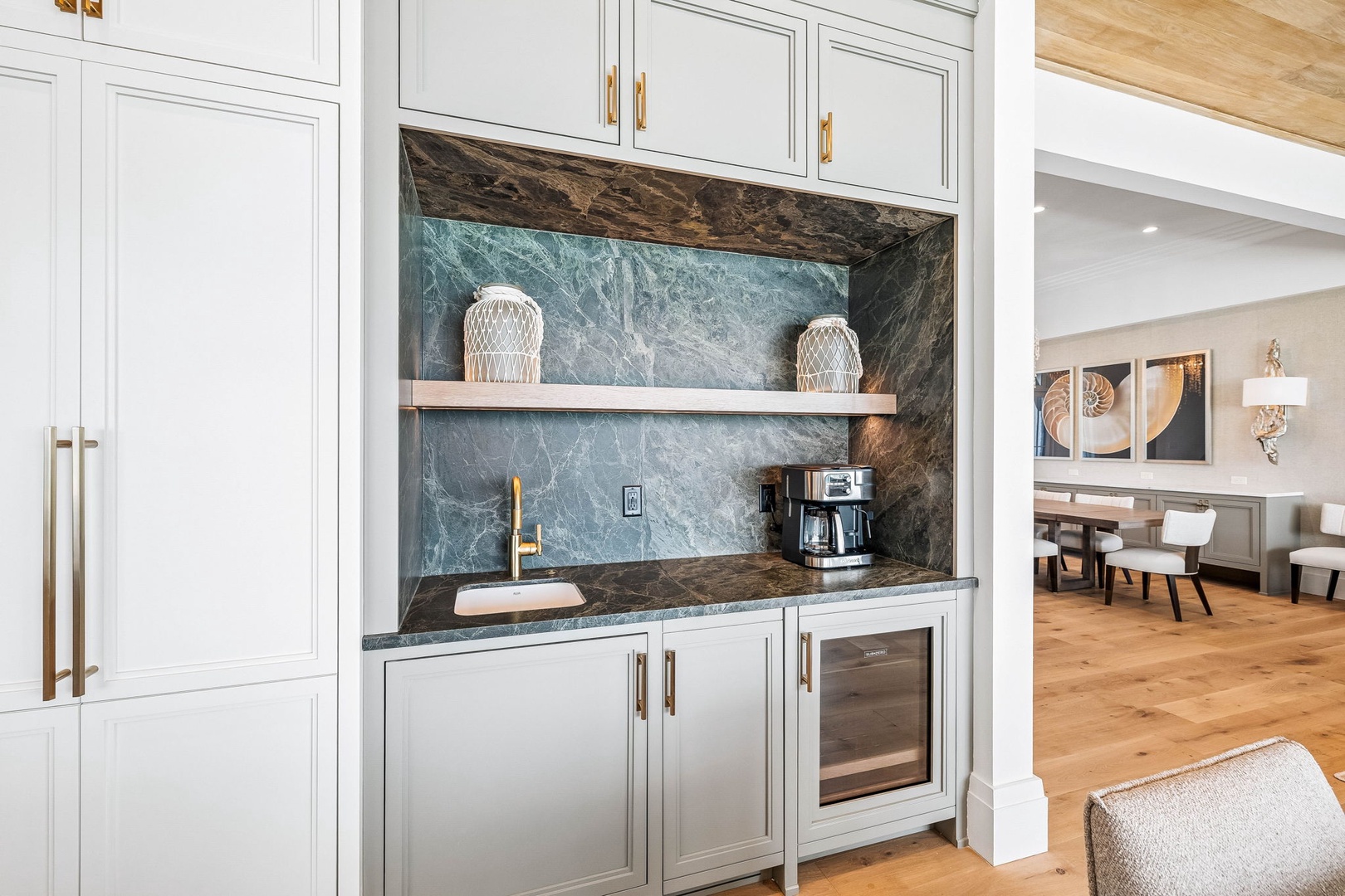 Your own stylish coffee bar awaits, complete with striking marble backsplash and gleaming gold fixtures—perfect for savoring your morning brew in refined comfort.