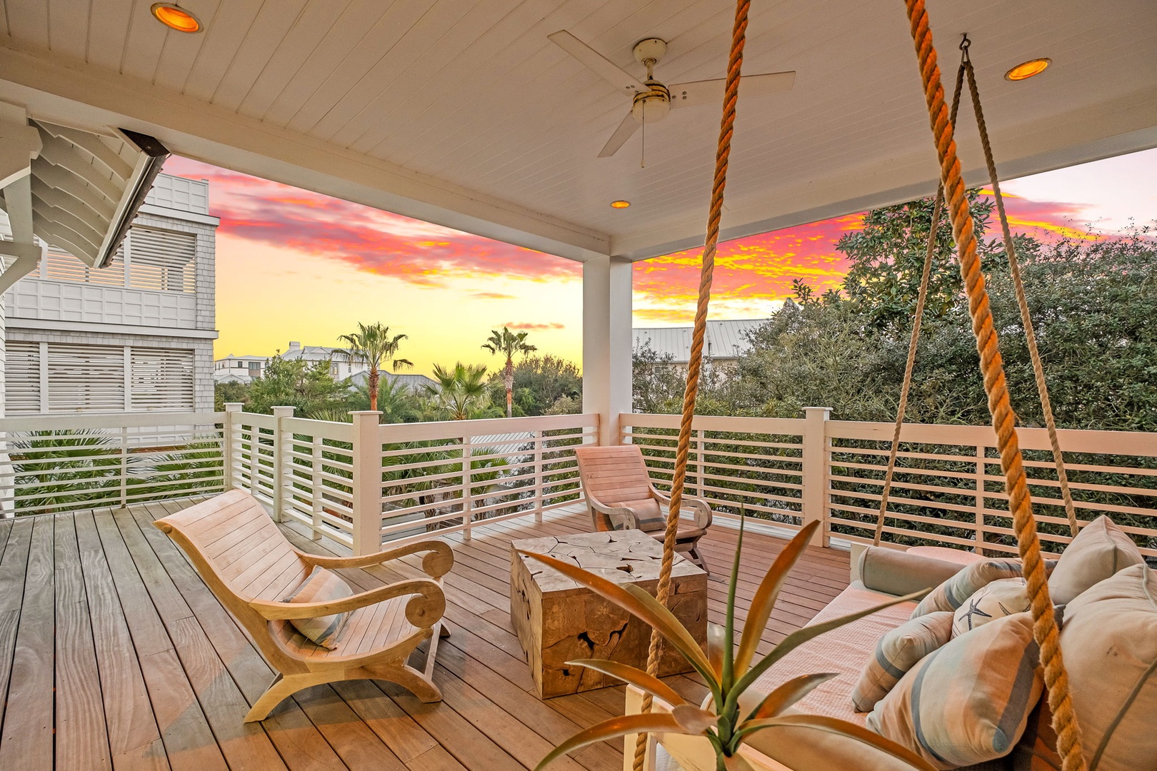 Unwind on your private balcony as breathtaking sunset colors paint the sky, with cozy seating and a rope swing creating the perfect evening retreat.