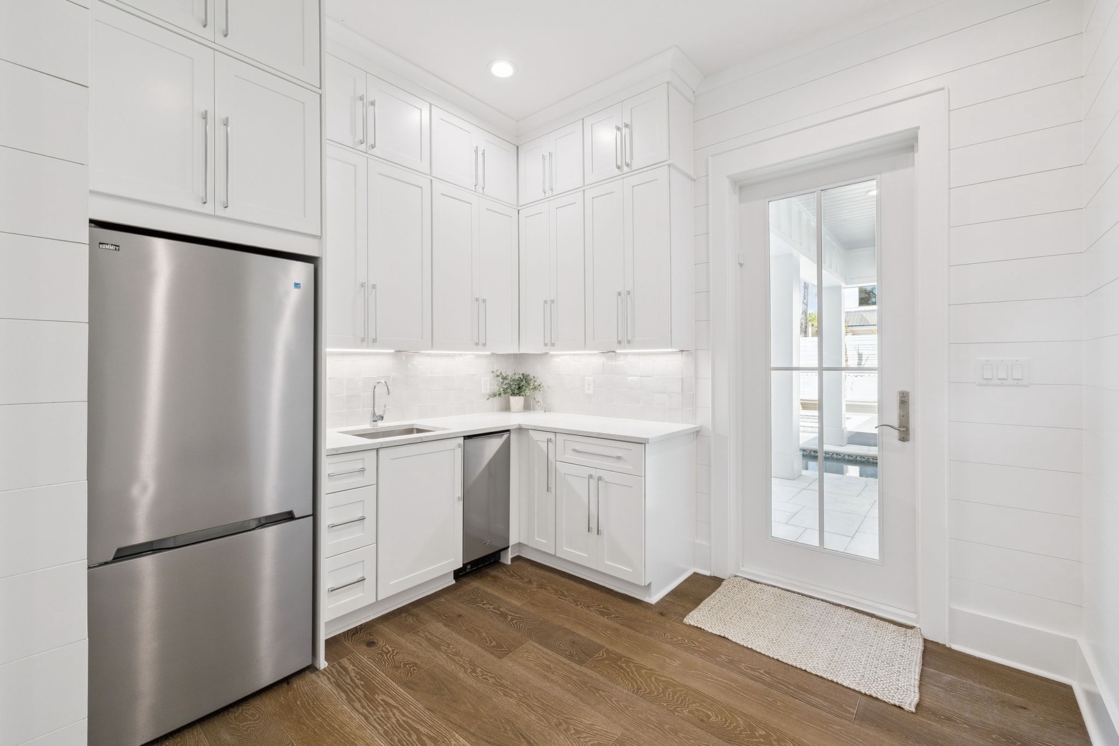 Your bright white kitchen features stainless steel appliances and ample cabinet storage, perfect for preparing meals during your stay.