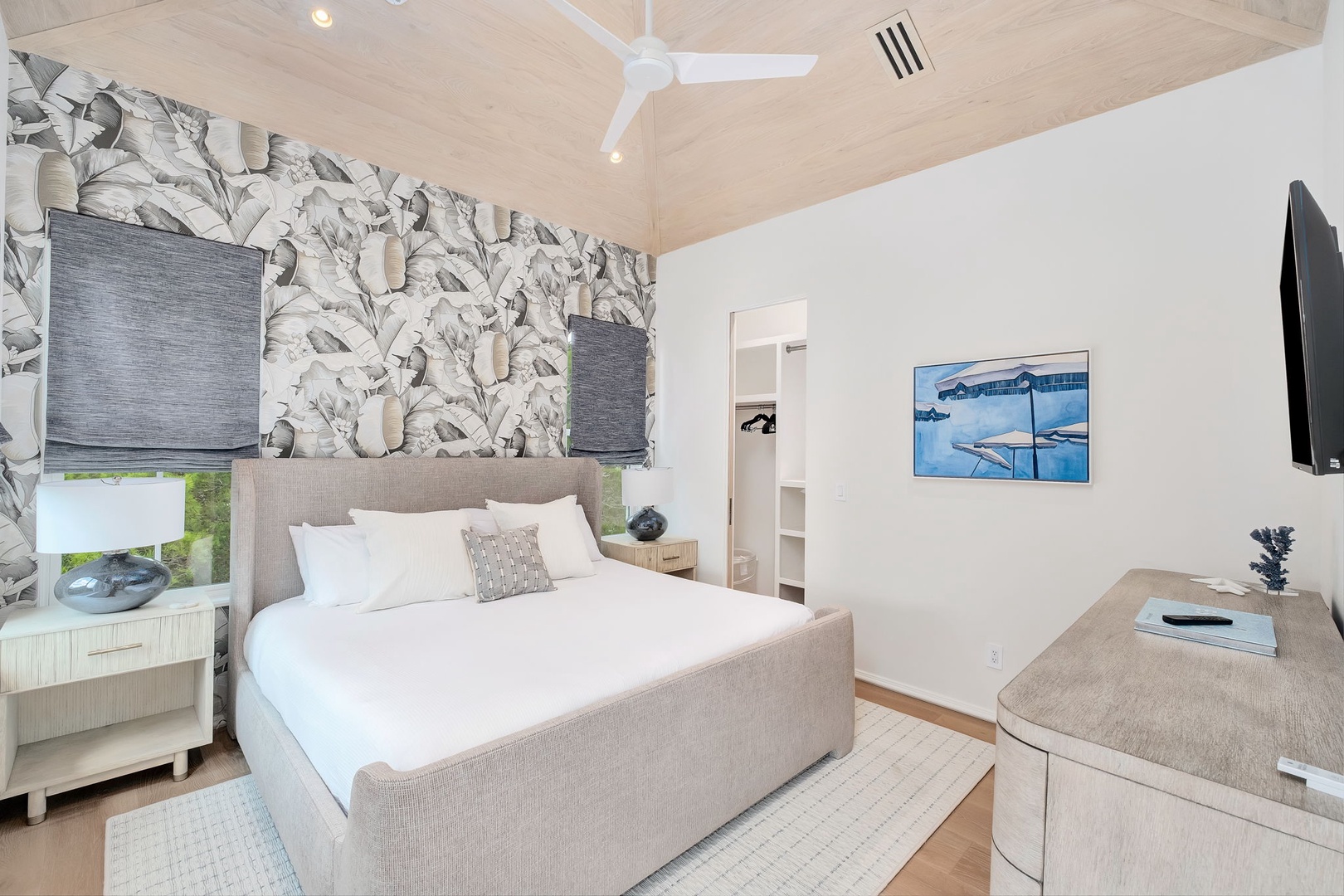 : Unwind in your serene sanctuary with tropical-print accents, vaulted ceilings, and a plush bed dressed in crisp white linens—the perfect retreat after a day of adventure.