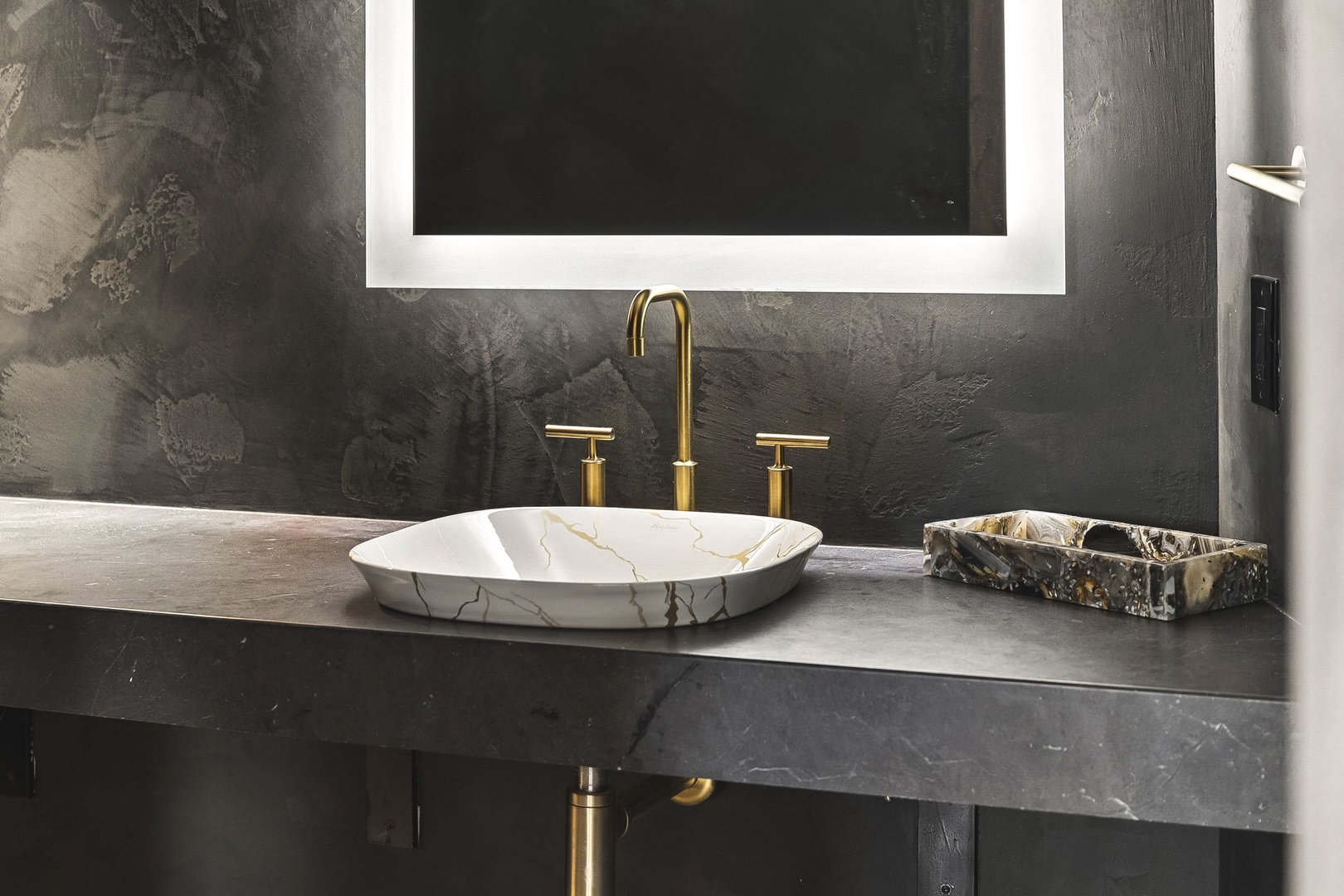 Sleek marble vessel sink with polished gold fixtures awaits your morning ritual on a modern floating vanity.