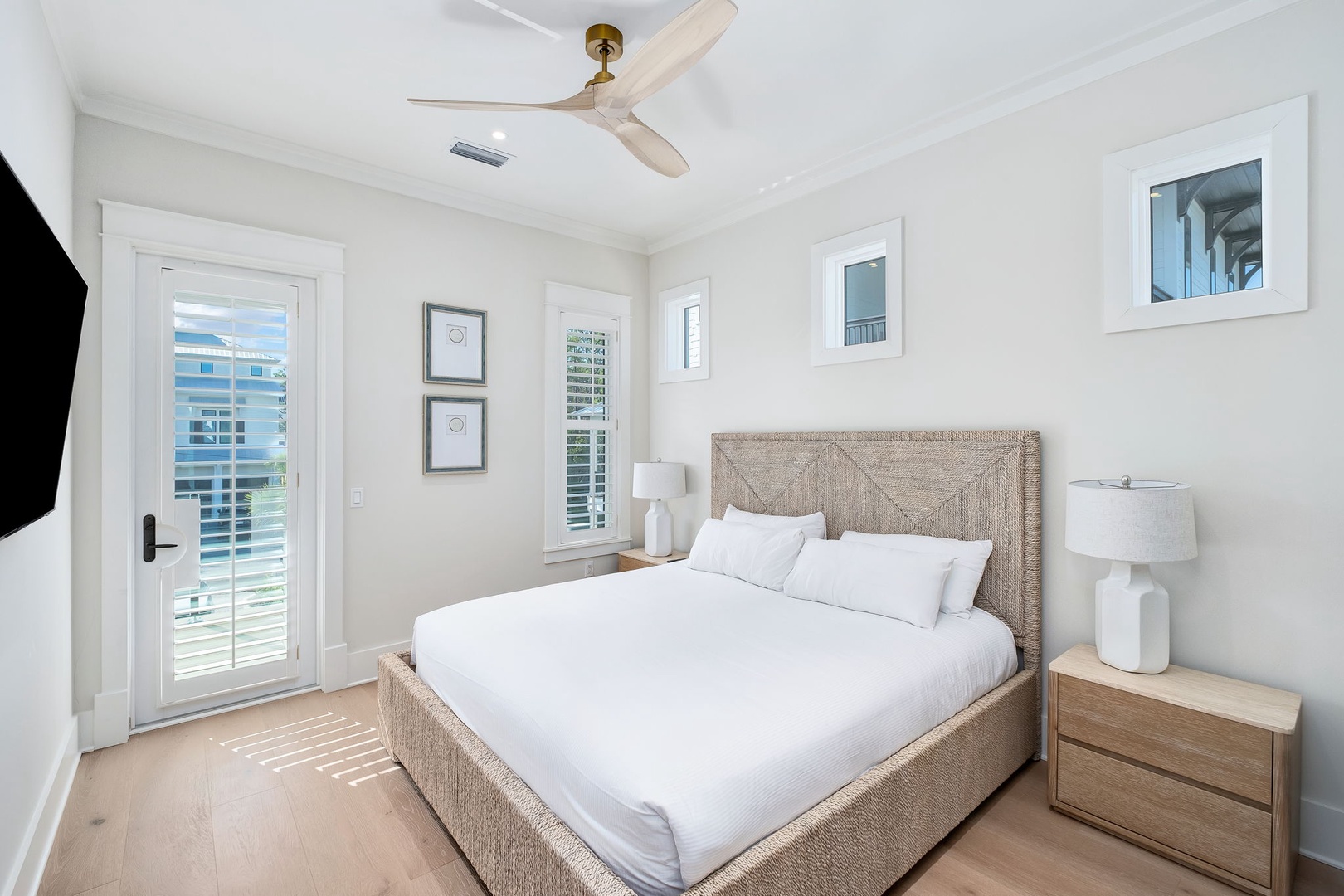 Your bright, airy retreat features a cozy woven bed and ceiling fan overhead. Natural light spills through your private balcony door, bringing fresh breezes and a tranquil coastal feel.