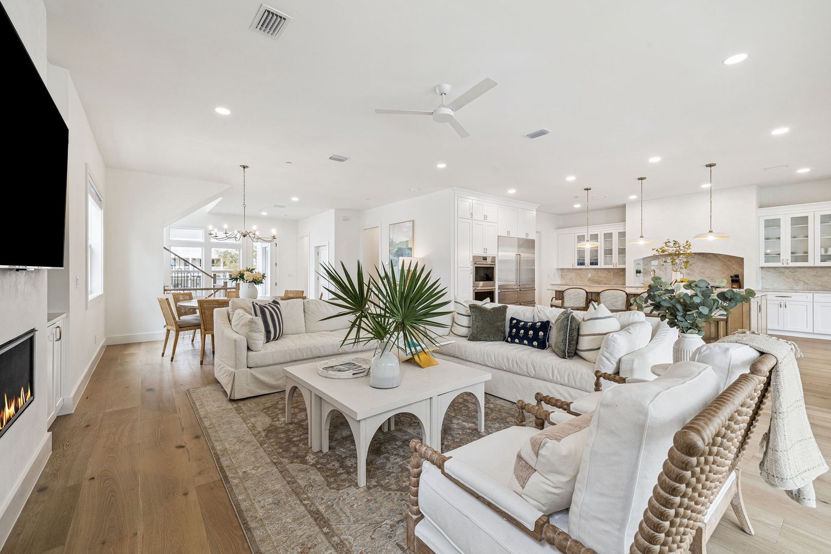 Your stylish open-concept living space awaits with plush seating, modern kitchen, and warm coastal touches throughout.