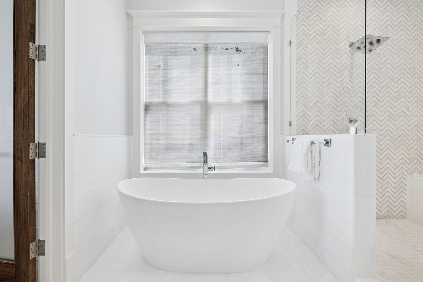 Unwind in your luxurious spa-like retreat with a stunning freestanding tub perfectly positioned beneath natural light for ultimate relaxation.