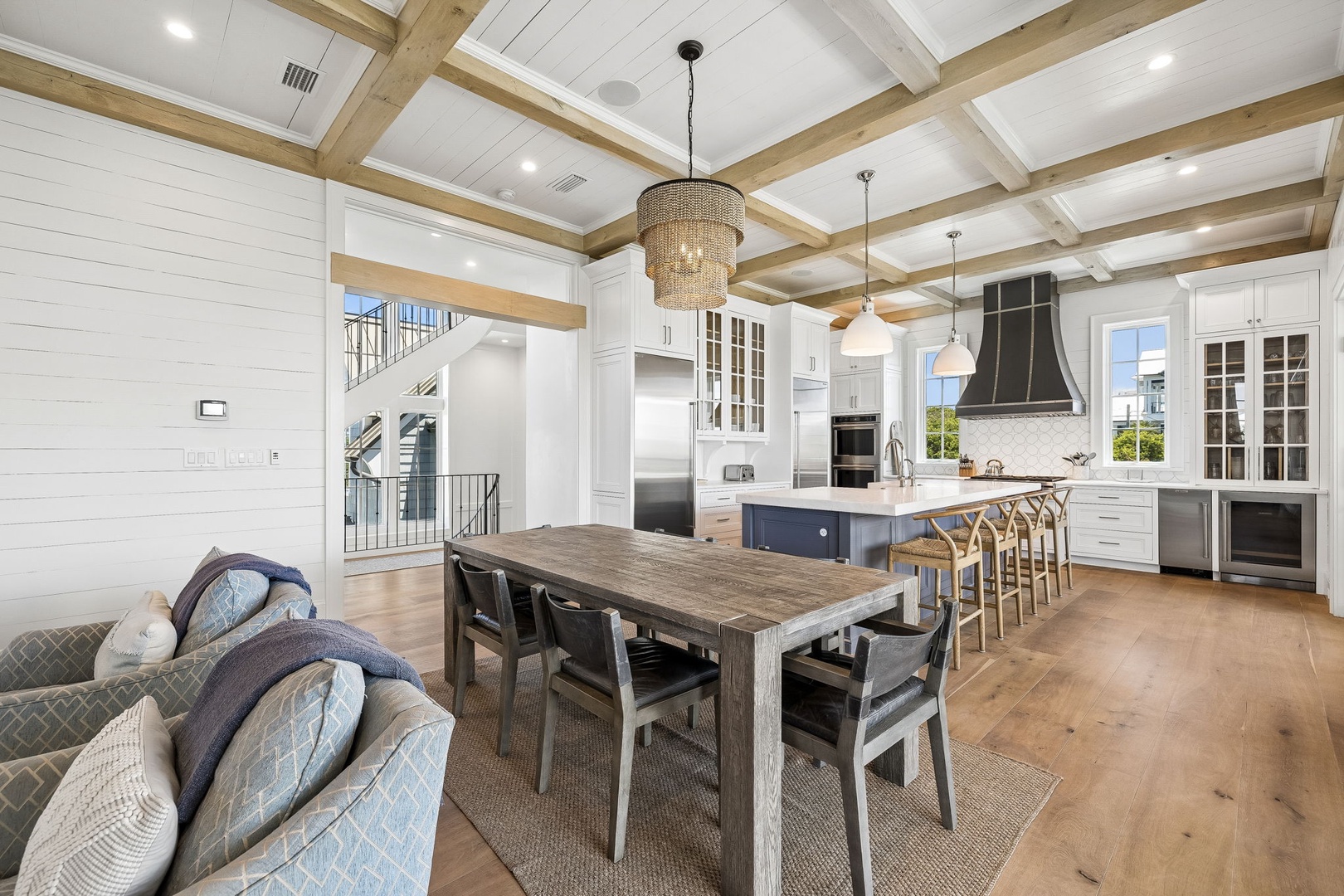 Step into an open living space where rustic beams meet modern elegance. Your gourmet kitchen awaits with sleek appliances, a spacious island for gathering, and warm wood tones throughout.