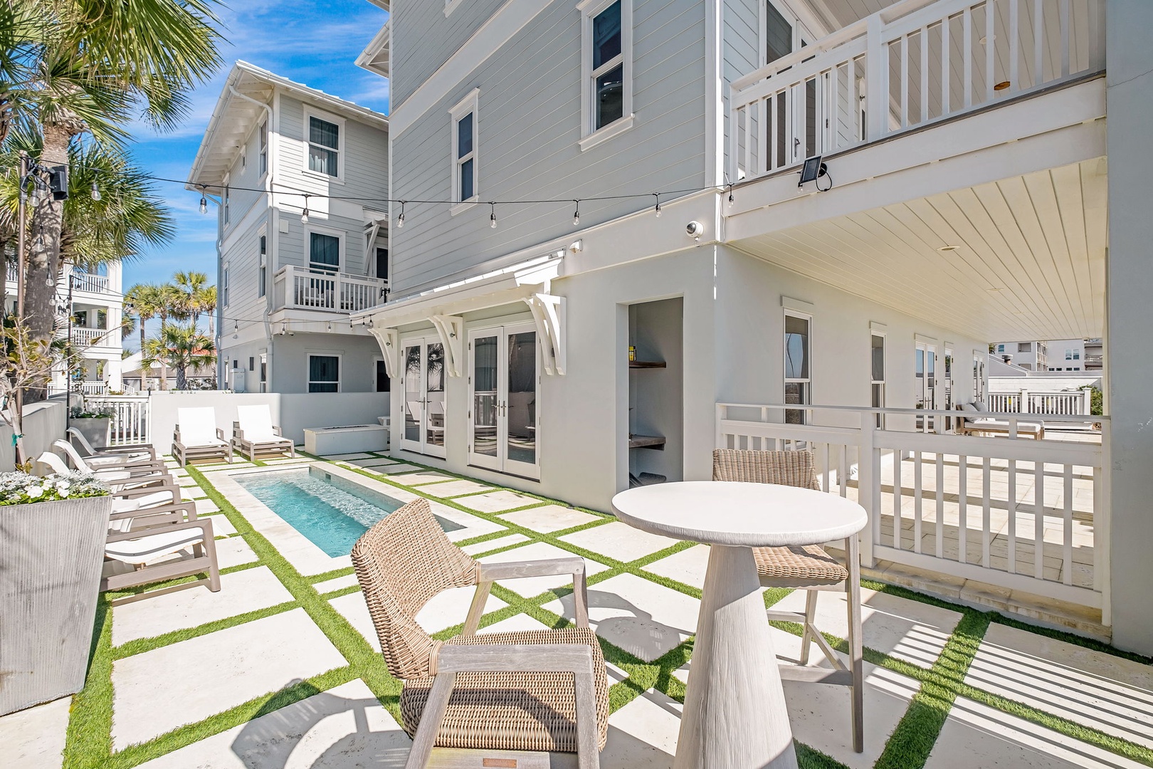 This sunny, palm-lined outdoor retreat features a sleek plunge pool, spacious patio seating, and airy covered dining—perfect for relaxing or entertaining under the Florida sky.