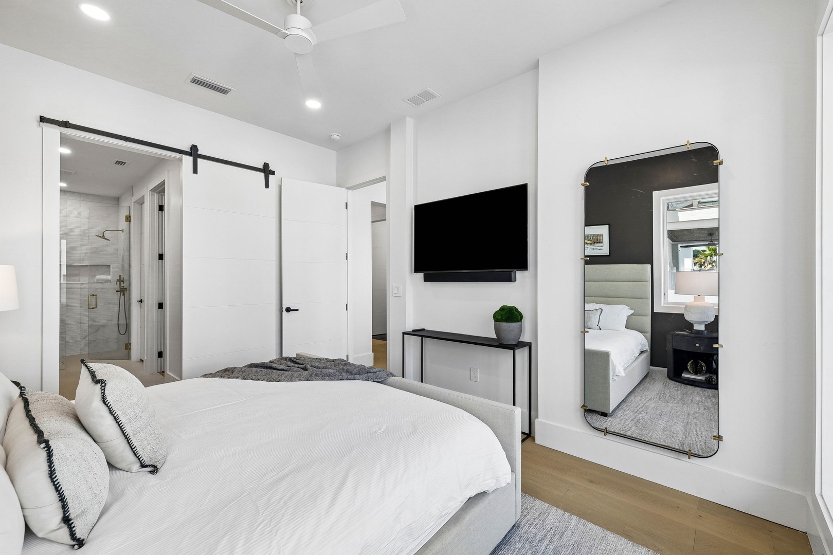 Sink into crisp linens and watch your favorite shows from bed. A sliding barn door reveals your private ensuite, and a full-length mirror helps you get ready for the day ahead.