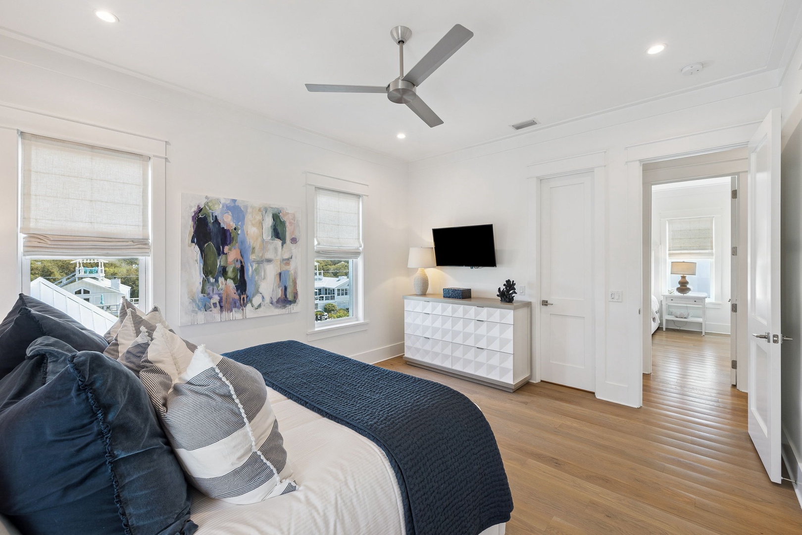 Relax in your serene master bedroom with soft linens, ceiling fan, and TV for cozy nights in.