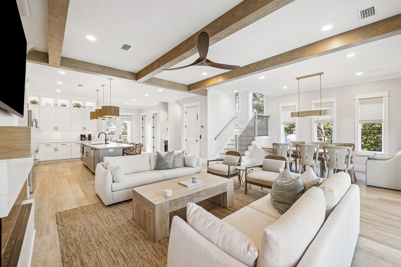 Relax in your spacious open-plan living space with soaring ceilings and natural wood beams creating the perfect coastal retreat atmosphere.