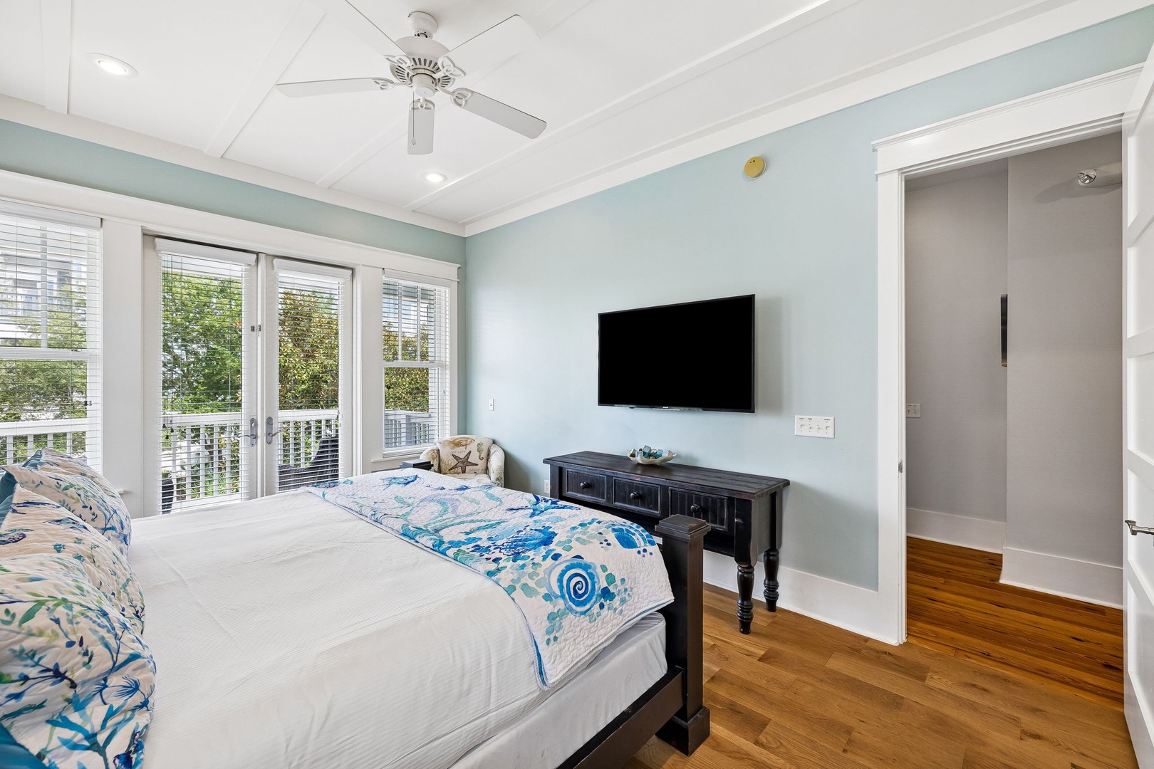 Wake up to natural light streaming through French doors in your peaceful bedroom retreat. Soft blue walls, rich wood floors, and a private en-suite create the perfect space for restful nights.